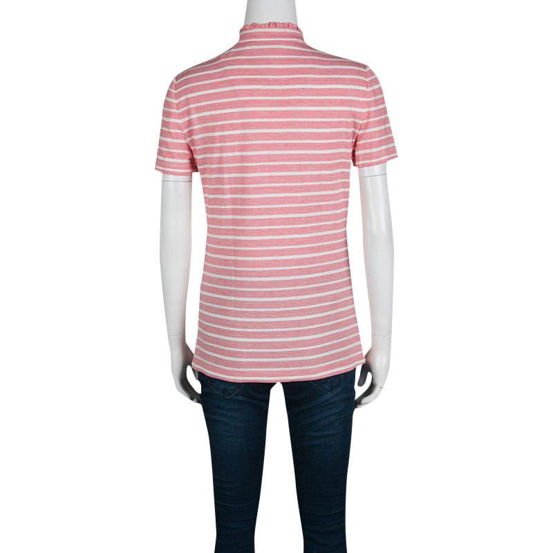 This Tory Burch creation features pink and white striped pattern and ruffle detail along the front buttons and high collar that add a feminine touch to the top, making it a pretty piece to flaunt on casual outings. Finished with short sleeves, the
