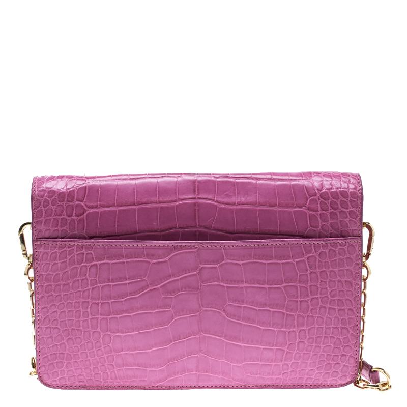 Crafted from pink croc-embossed leather, this beautiful Tory Burch bag has the popular envelope design. The leather lined interior is sized to hold your party essentials. The chic bag is complete with a removable chain link strap.

Includes: