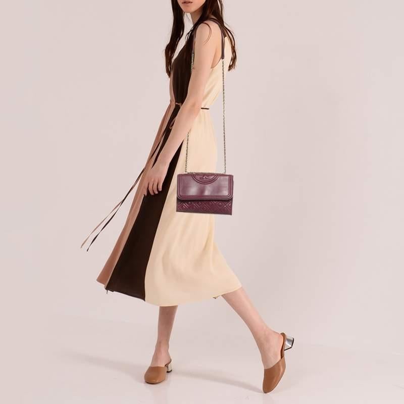 This Fleming shoulder bag from Tory Burch has been meticulously crafted from leather in a dreamy hue and designed with quilts in diamond patterns and the logo on the top. The flap opens to a fabric lined interior and the bag is held by an interwoven