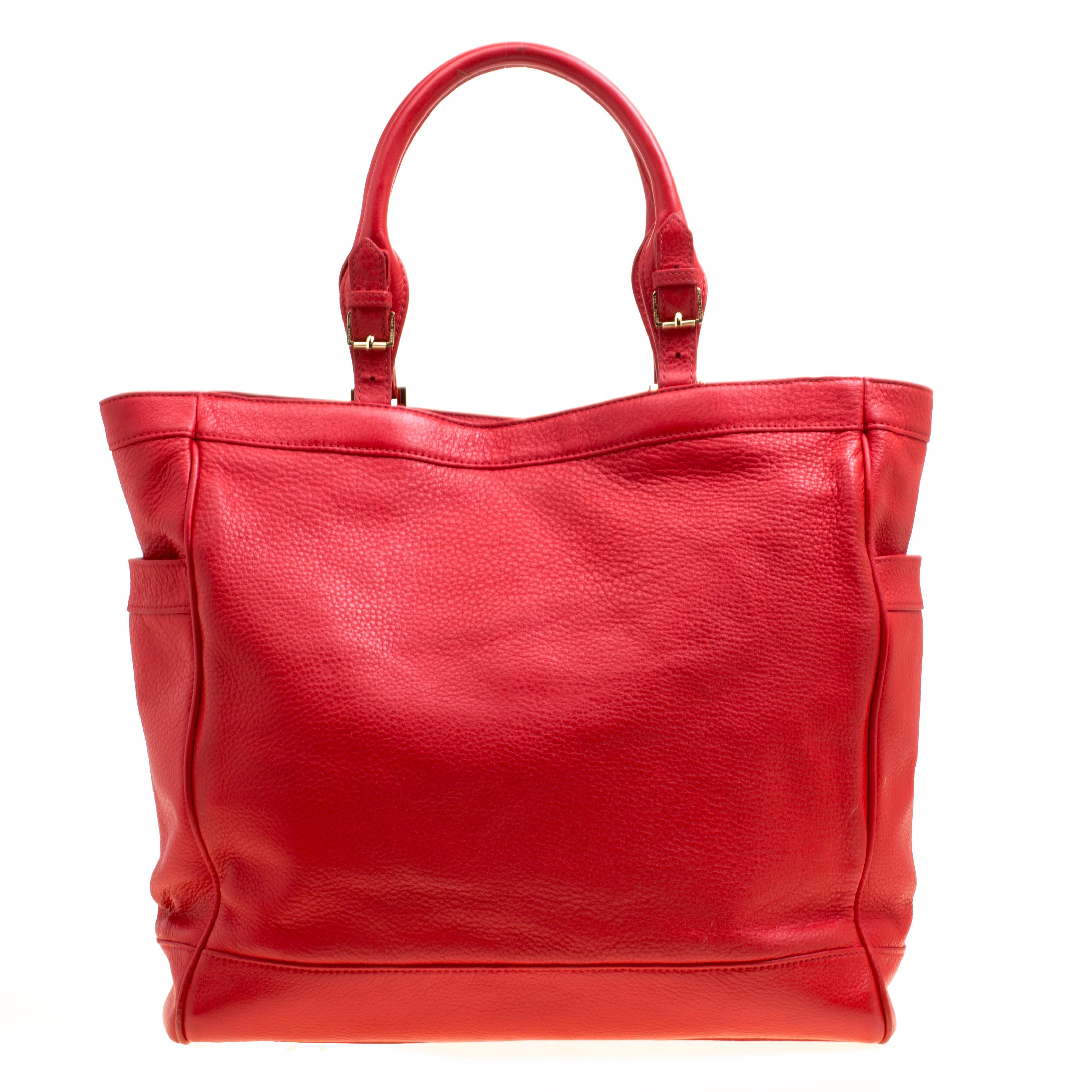 This beautiful, red Tory Burch beauty will give your look a touch of class and elegance. It is crafted from smooth leather and is adorned with logo accents on the front and two slip pockets on each side. The well-designed exterior is coupled with