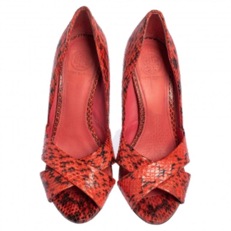 Add a luxe finish to your ensemble with this pair of pumps from the house of Tory Burch. Finely crafted from snakeskin, these red shoes will offer comfortable support. The peep-toe pumps are set atop leather soles and 10 cm heels. NOTE: AVAILABLE