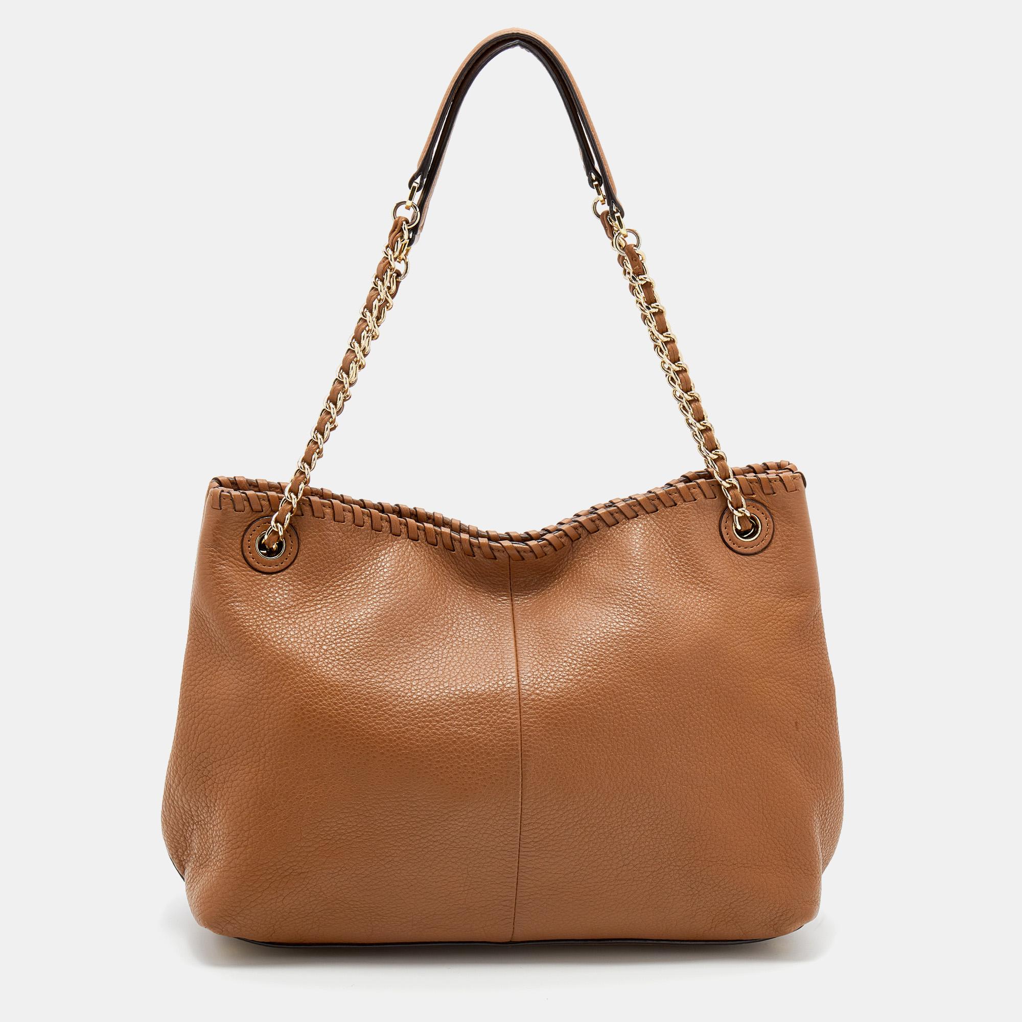 This stylish Marion tote comes from the House of Tory Burch. It is crafted from tan leather on the exterior, which is embellished with whipstitch detailing. It features two handles, gold-toned hardware, and a fabric-lined interior. This creation is