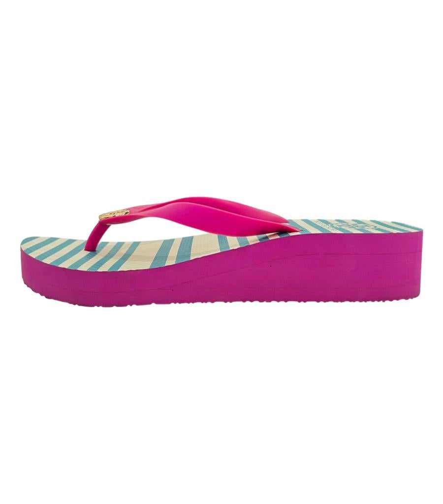 Tory Burch Thadine Wedge Flip Flop Sandals
Fuchsia pink wedges with blue and white striped insoles.
Detailed with pink thong straps detailed with gold 'TT' logo to the centre.
Size – L (Length 24.5cm, Width 9cm)
Condition – Good/Very Good (Some
