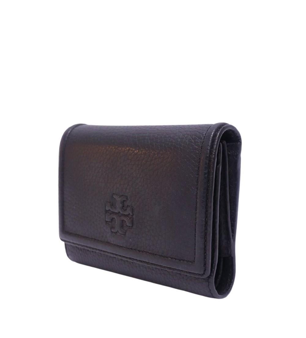 Tory Burch Thea Leather Wallet, Features back pocket, 4 slip pockets, 1 zipper pocket and 8 card slots.

Material: Leather
Height: 14cm
Width: 10.5cm
Depth: 2.5cm
Overall condition: Good
Interior condition: Signs of use
External condition: Light