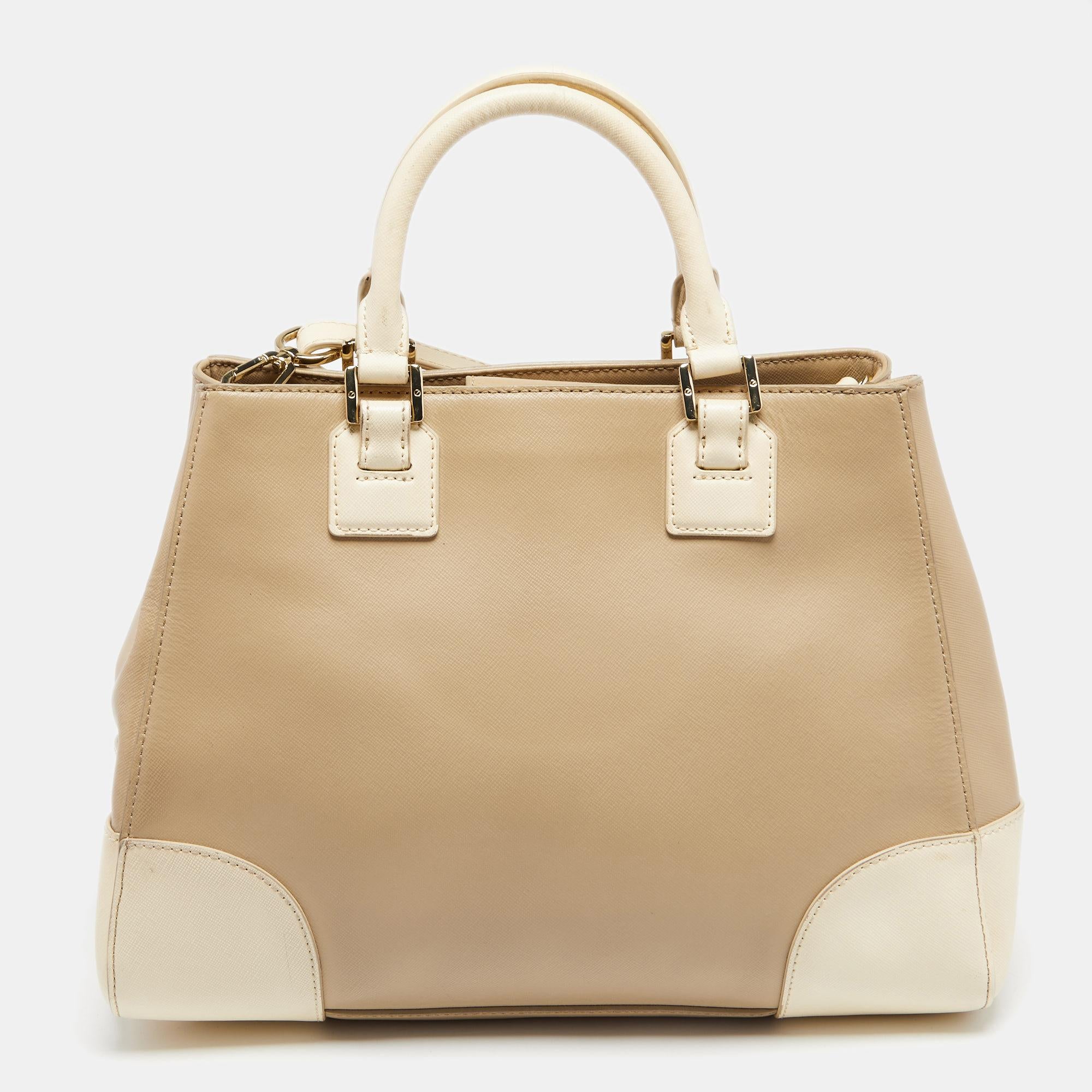 This Tory Burch leather tote has been crafted with attention to detail. Lined with fabric, the roomy interior has an ample amount of space to keep your belongings safe. While the dual handles and a shoulder strap make it comfortable to carry, the