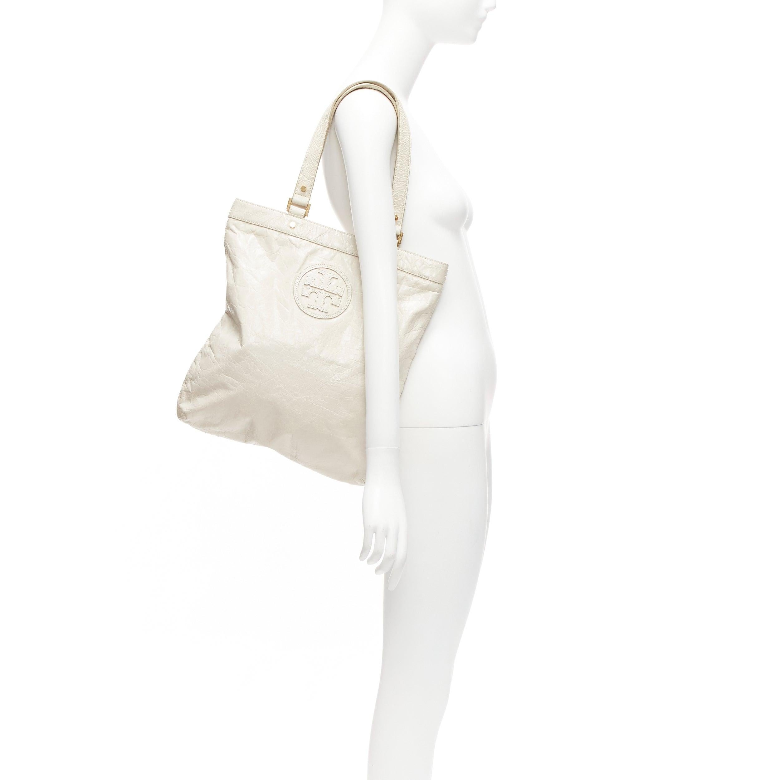 TORY BURCH white textured leather logo patch gold hardware A4 tote bag
Reference: CELG/A00404
Brand: Tory Burch
Material: Leather
Color: White, Gold
Pattern: Solid
Closure: Snap Buttons
Lining: Beige Fabric

CONDITION:
Condition: Very good, this