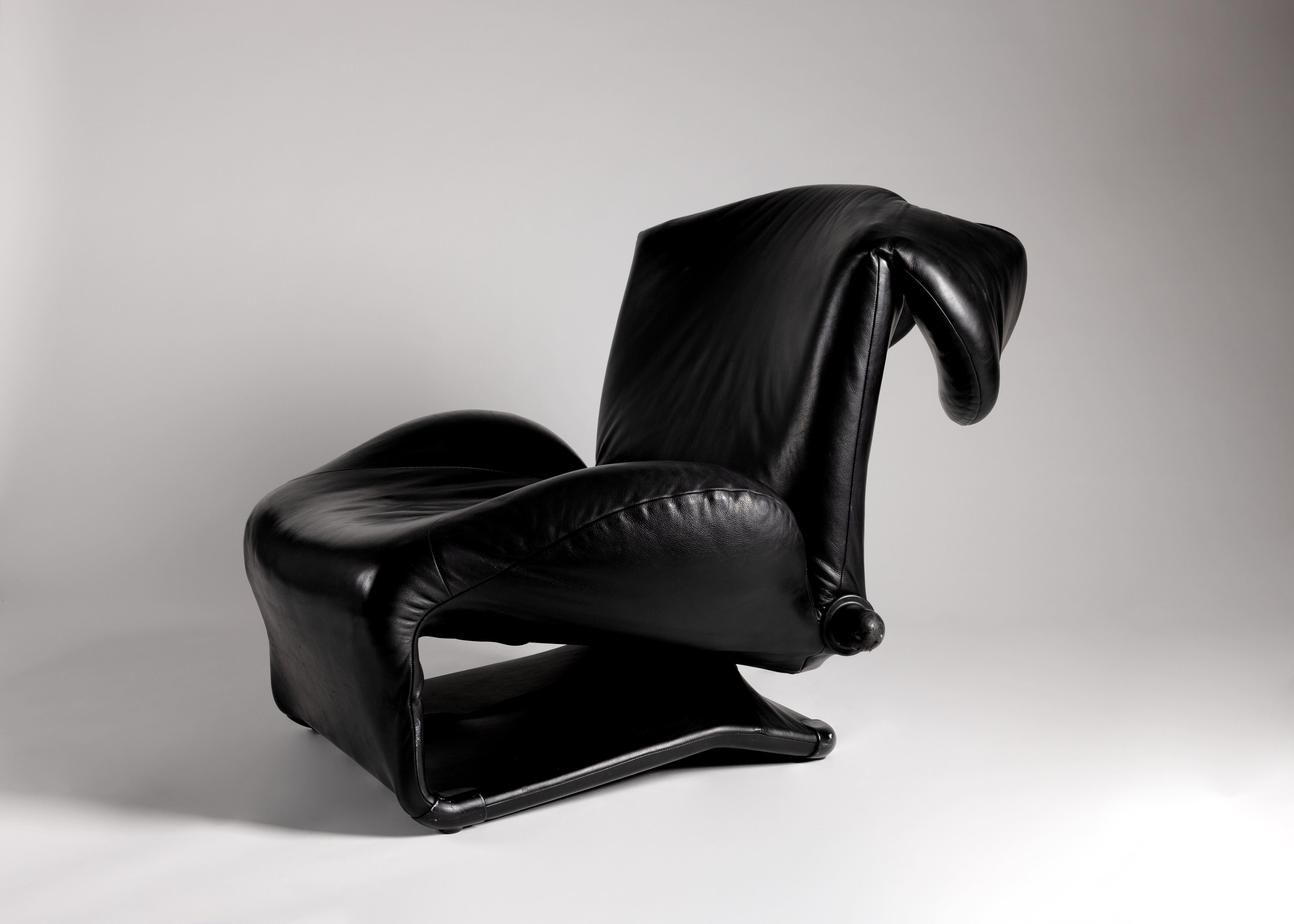 This sleek black leather armchair unfolds into a variety of comfortable shapes.