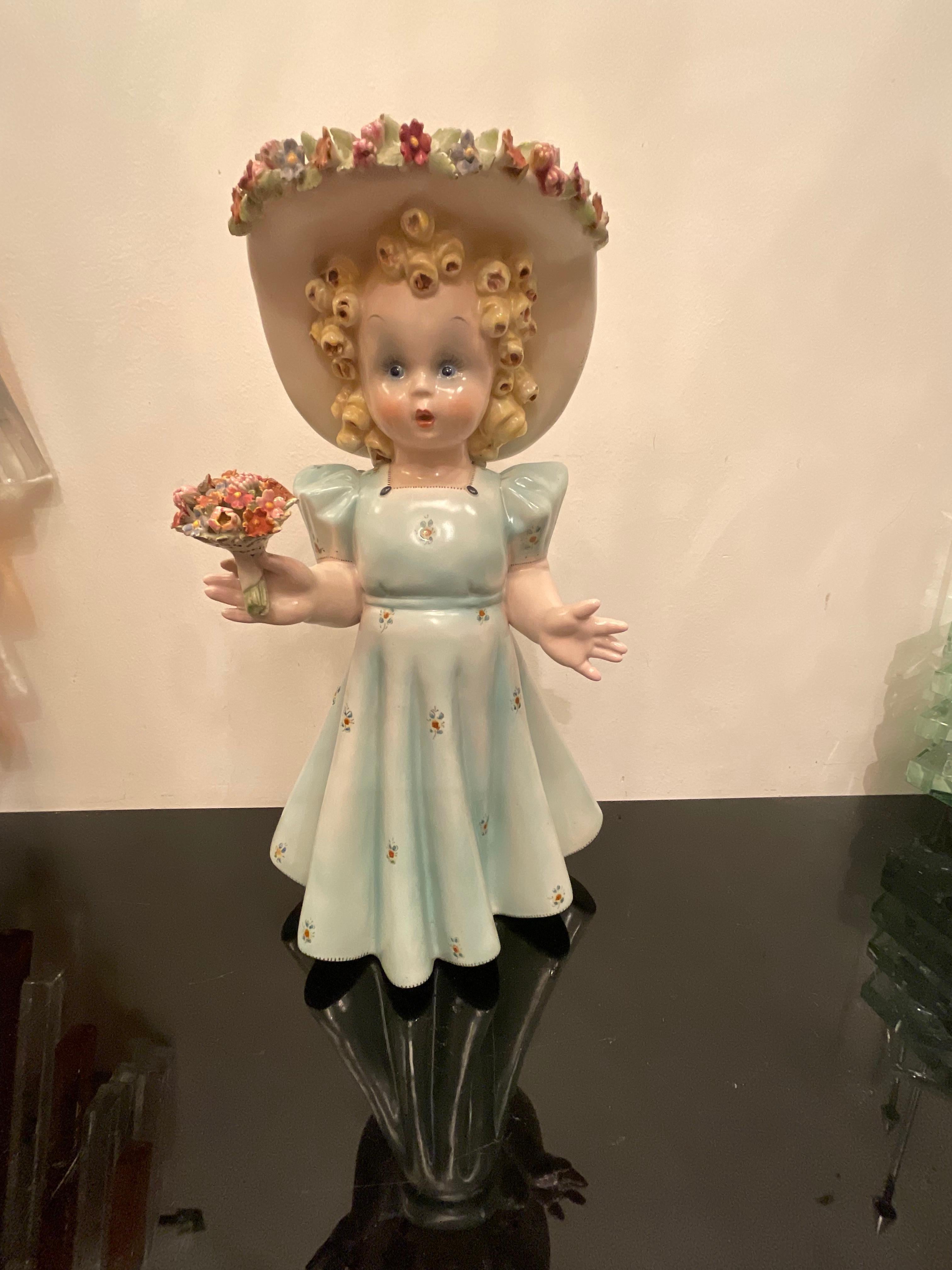 Tarciso TOSIN - A ceramic sculpture depicting a little girl ,made in VICENZA in '1940, ITALY.
Hand-painted and painstakingly detailed, with a bouquet of flowers in her hand is flowers in the capellina, bears the signature of Manifattura Tosin in the