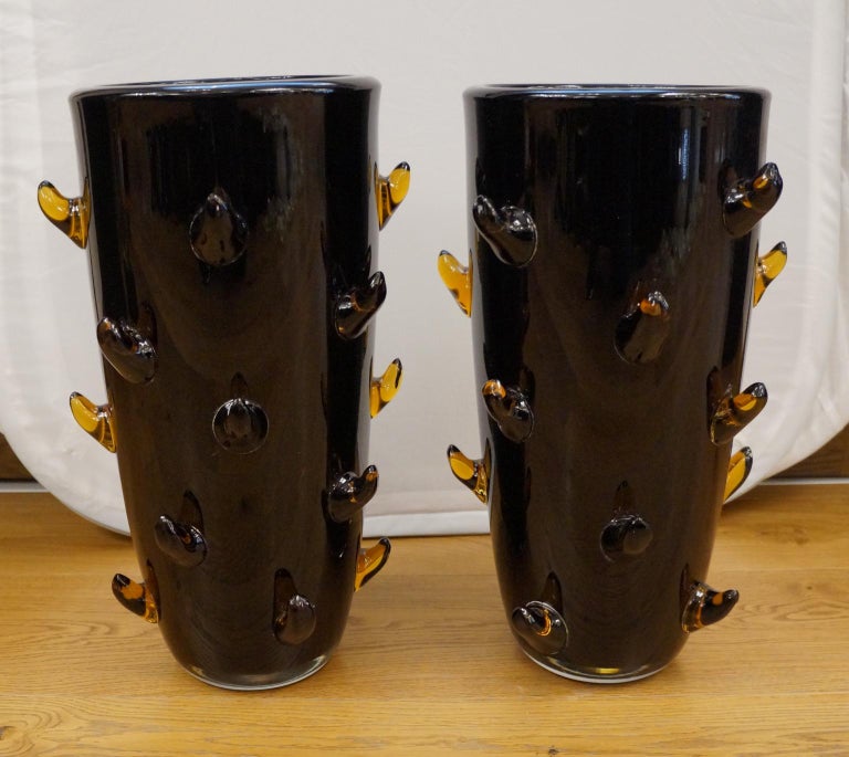 Two Murano glass blown vases, black color with amber tips.
The vases are of thick glass.
This fantastic Mid-Century Modern style artwork will add an extra touch of class to your environment.
Project by Toso Murano in 1988s
Vases signed with