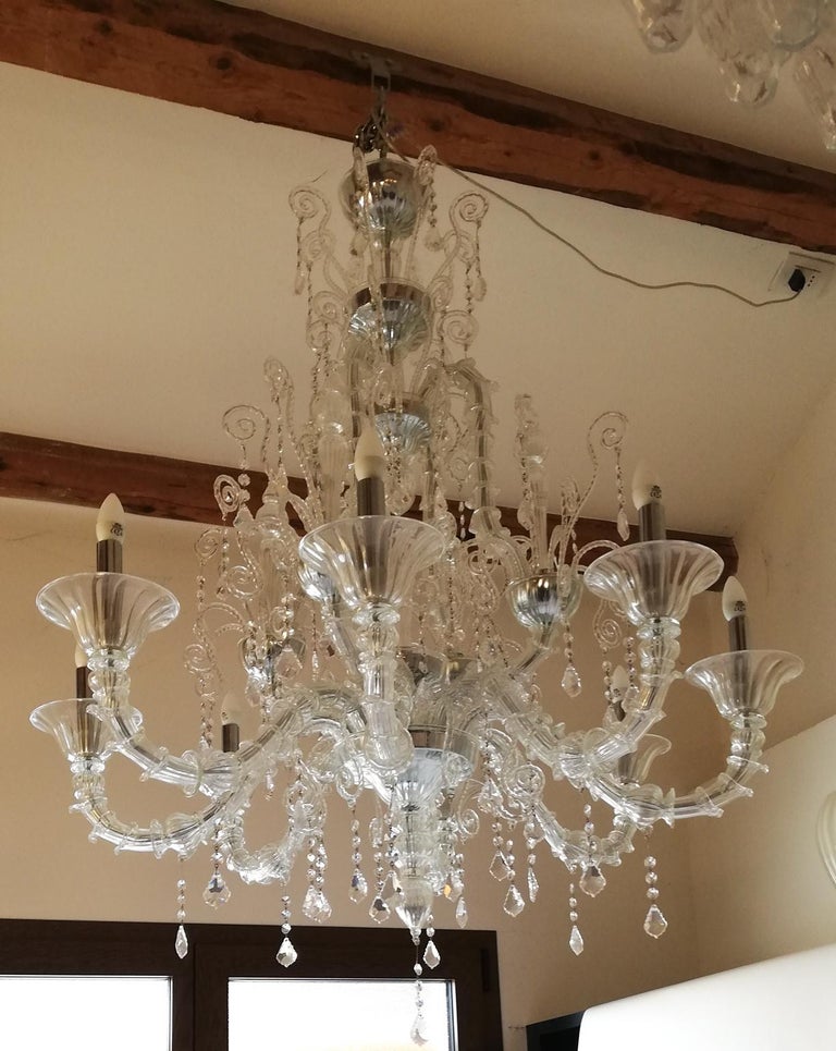 Here is a beautiful chandelier designed in 1989 by Toso Murano. Very Classic, this chandelier is composed of eight Classic style arms, each with two swarosky stripes that go down, embellishing it even more. It is a chandelier that leaves you