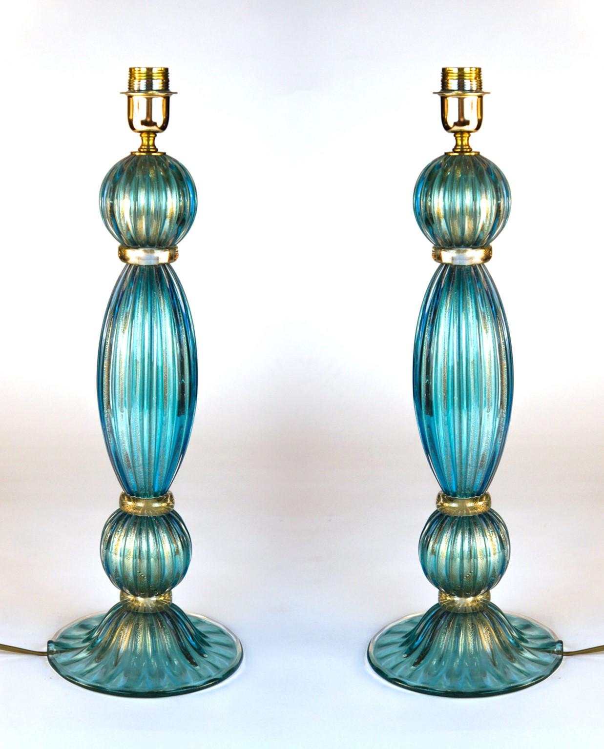 Exclusive pair of Murano glass table lamps aquamarine colour in 24 carat gold leaf. 
By touching the lamps, you can hear the various grooves made especially by the 