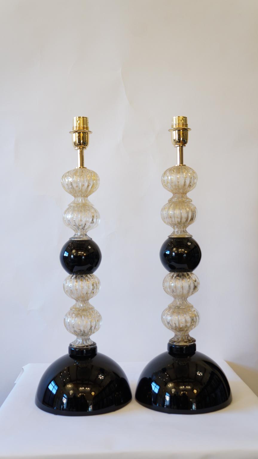 These are elegant Murano glass lamps, the ones you see pictured. 
They were designed for the first time in 1982 by Toso Murano and are magnificent. 
They are composed of four spherical elements that follow each other divided by ball black. The