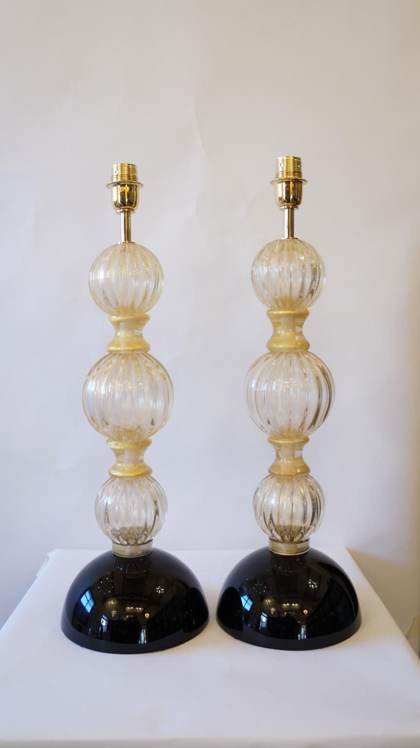These are elegant lamps, the ones you see pictured. 
They were designed for the first time in 1985 by Toso Murano and are magnificent. 
They are composed of four spherical elements that follow each other divided by rings containing 24k gold. The