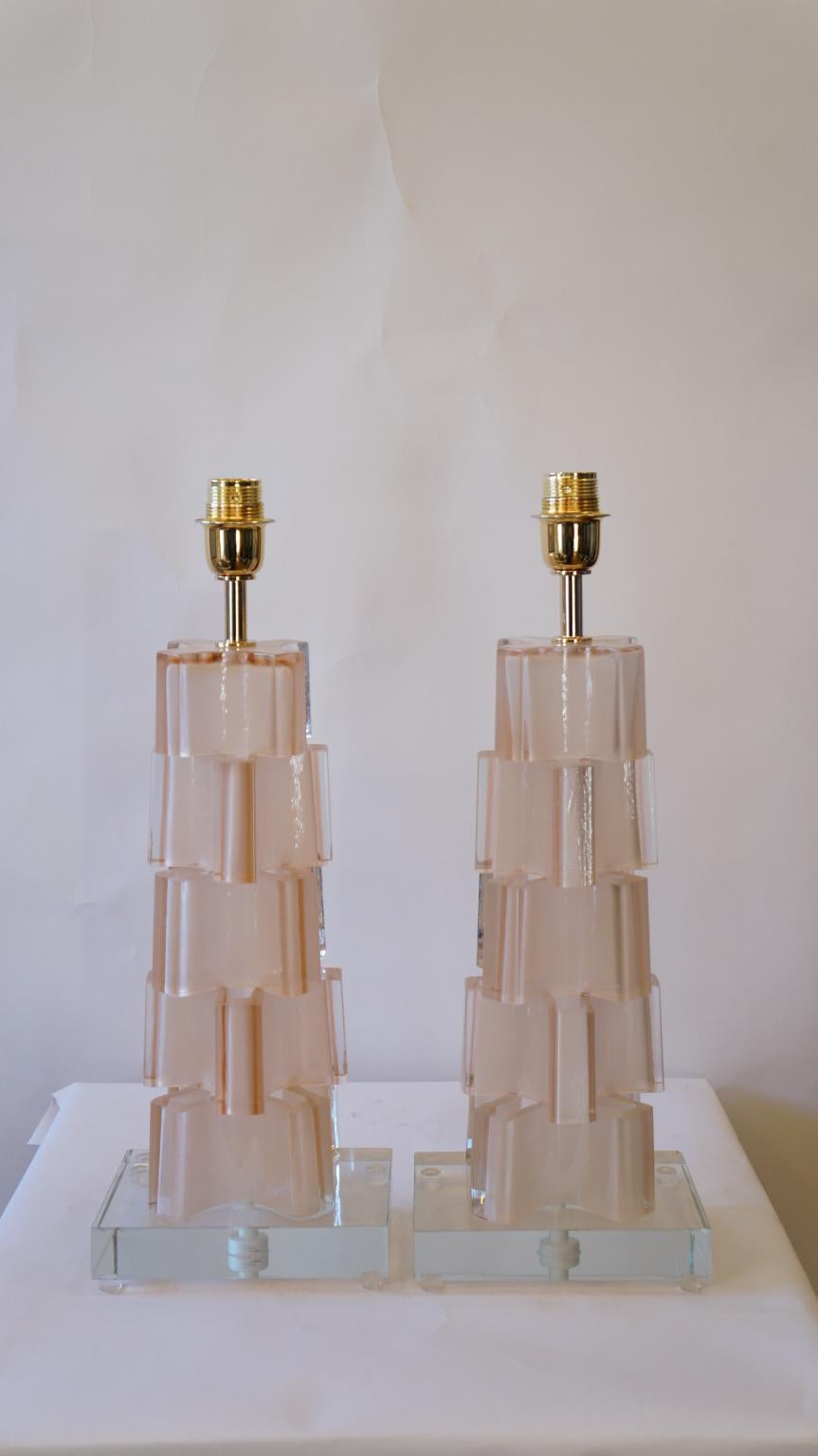 Le lampade che vedi nell'immagine sono realizzate in uno stampo e poi successivamente tagliate in diversi punti per dare un effetto meno lineare rispetto alle classiche lampade di Murano. Il vetro caldo viene fatto scorrere all'interno dello stampo