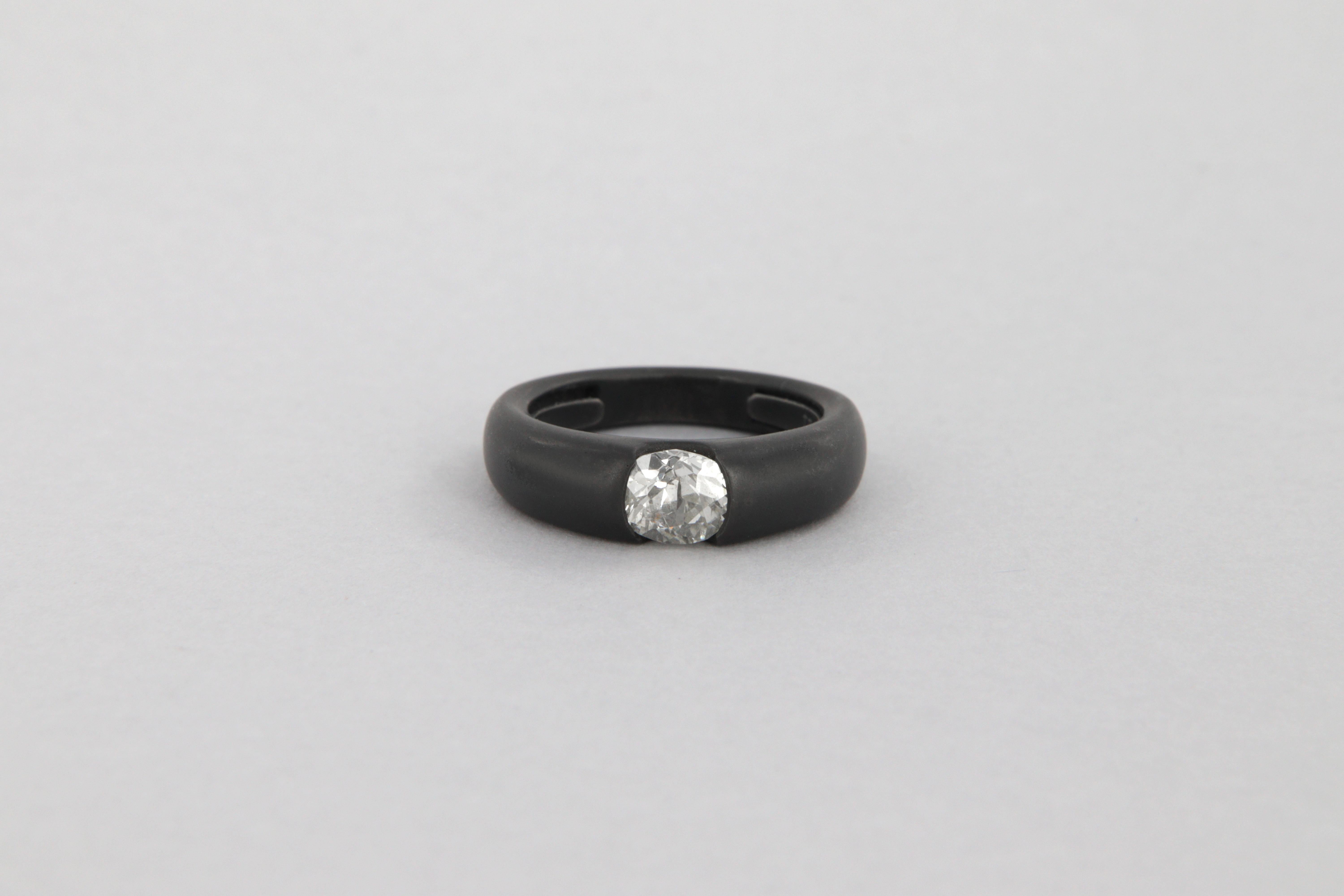Anello in oro bianco 18kt e rutenio nero opaco, peso g 8,3, con diamante taglio antico purezza P1, colore H-I, peso carati 1,12.
L'anello è costruito con una molla interna per poter adattarlo a differenti misure più piccole dell'attuale 7 (USA). Die