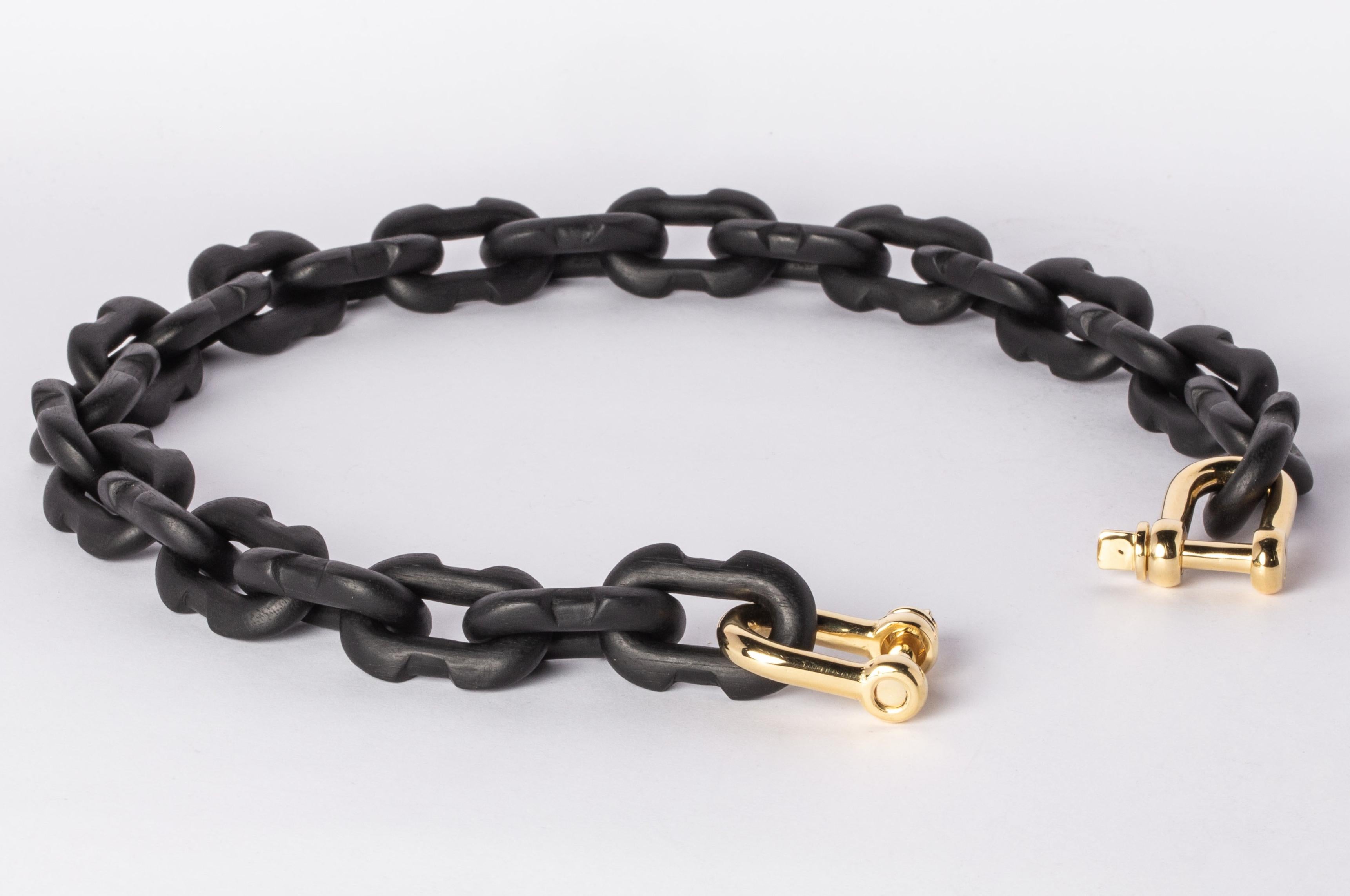 Chain necklace made of brass and wood. All organic chain is carved by hand. In the case of the chains made of wood, they are absolutely seamless; carved from a single long slab of wood (see link). 
The Charm System is an interrelated group of