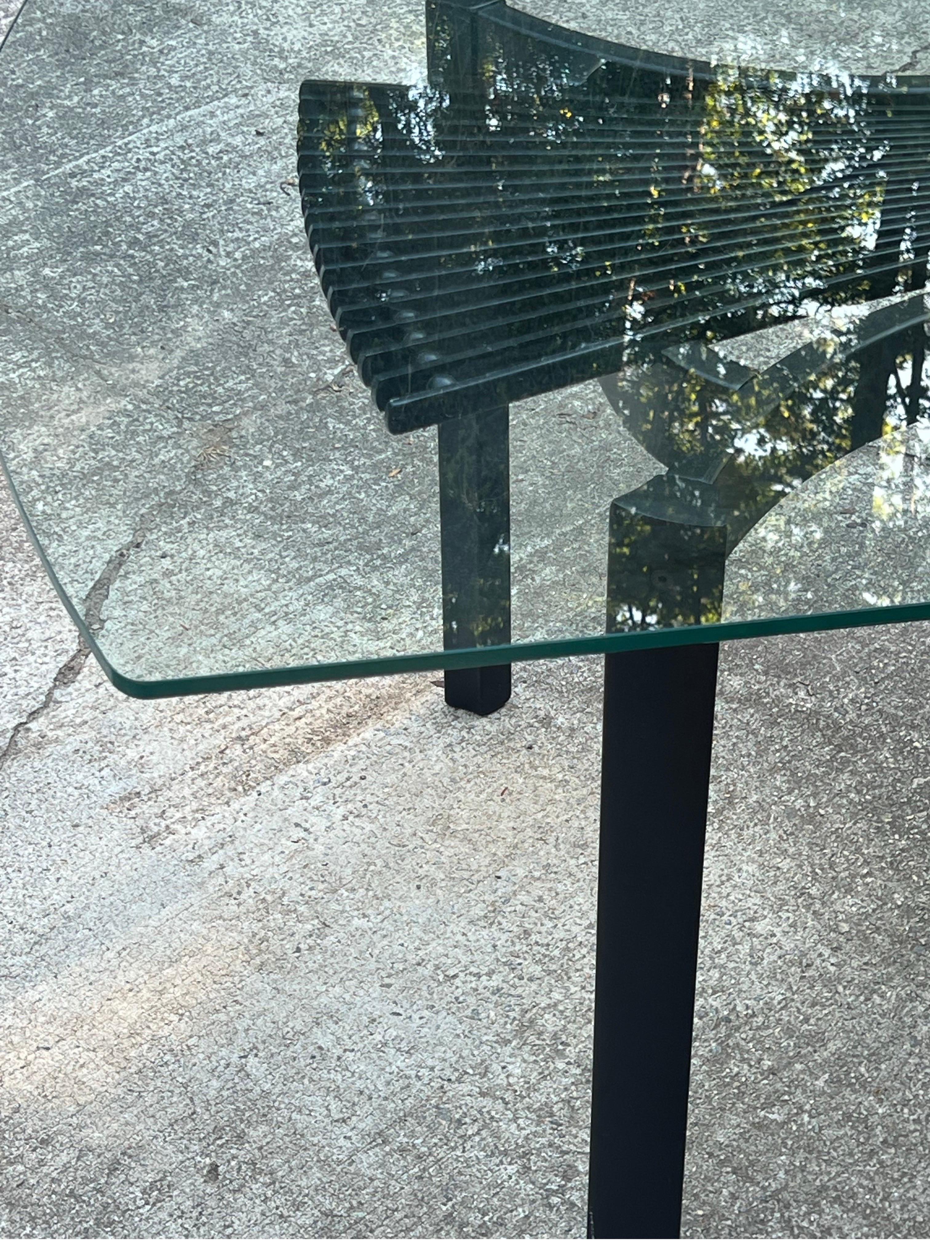 Postmodern glass top dining table designed by Torstein Nilsen for Westnofa, Norway. This table is a part of the Totem dining set and features a large rectangular glass top with rounded ends. The glass sits atop an ebonized wooden base. The center of