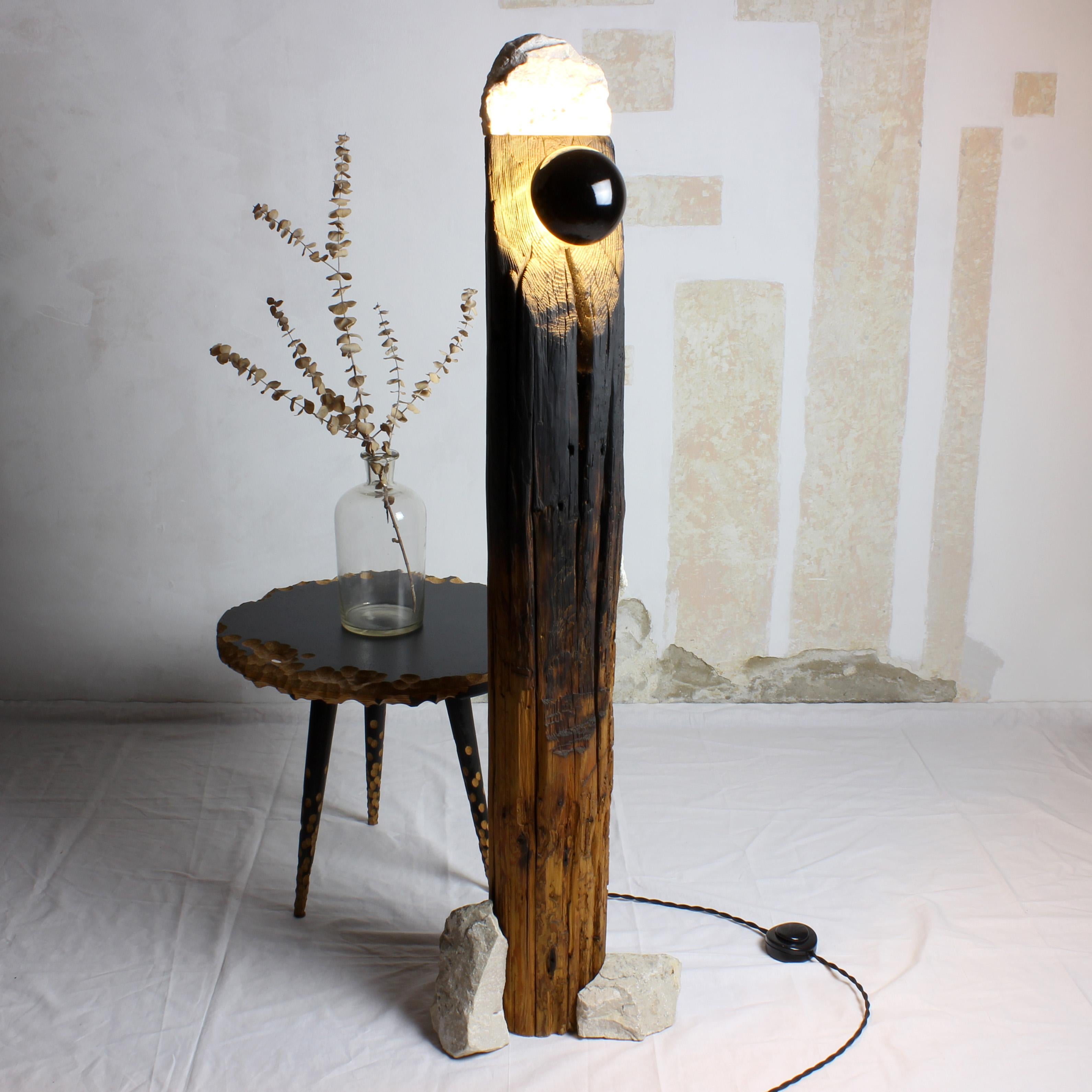 Lámpara de pie Totem by Gabor Gobi
Pieza única.
Dimensiones: P 18 x An 30 x Al 109 cm.
Materiales: Madera de pino y piedra.

Esta distintiva lámpara de pie emana de una columna de madera envejecida artísticamente reutilizada, complementada con