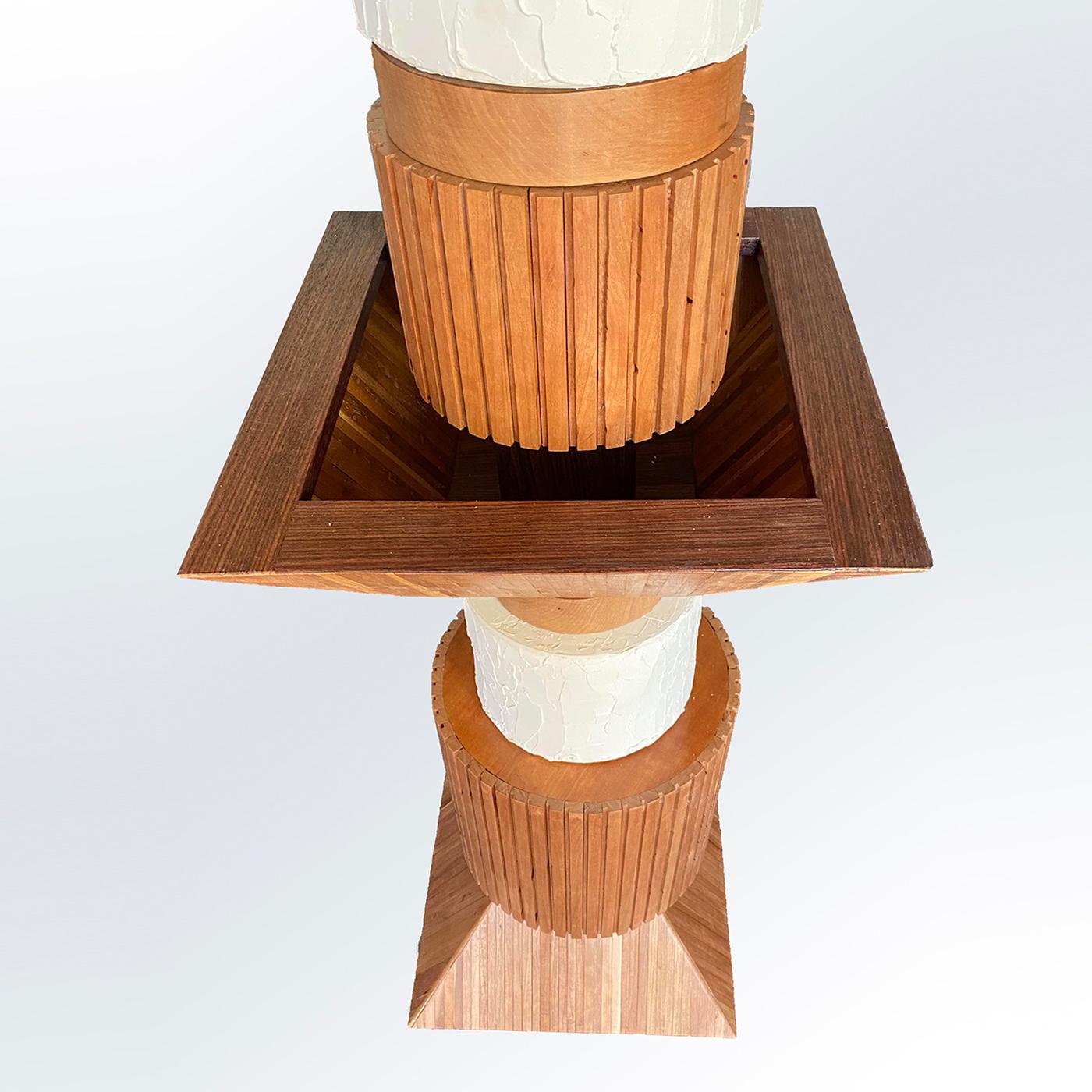 Esta escultural lámpara de pie inspirada en el feroz diseño de los tótems será el punto focal de un dormitorio o salón modernos. Su imponente estructura combina cilindros macizos de cerezo, pirámides truncadas y paralelepípedos, animados por ranuras