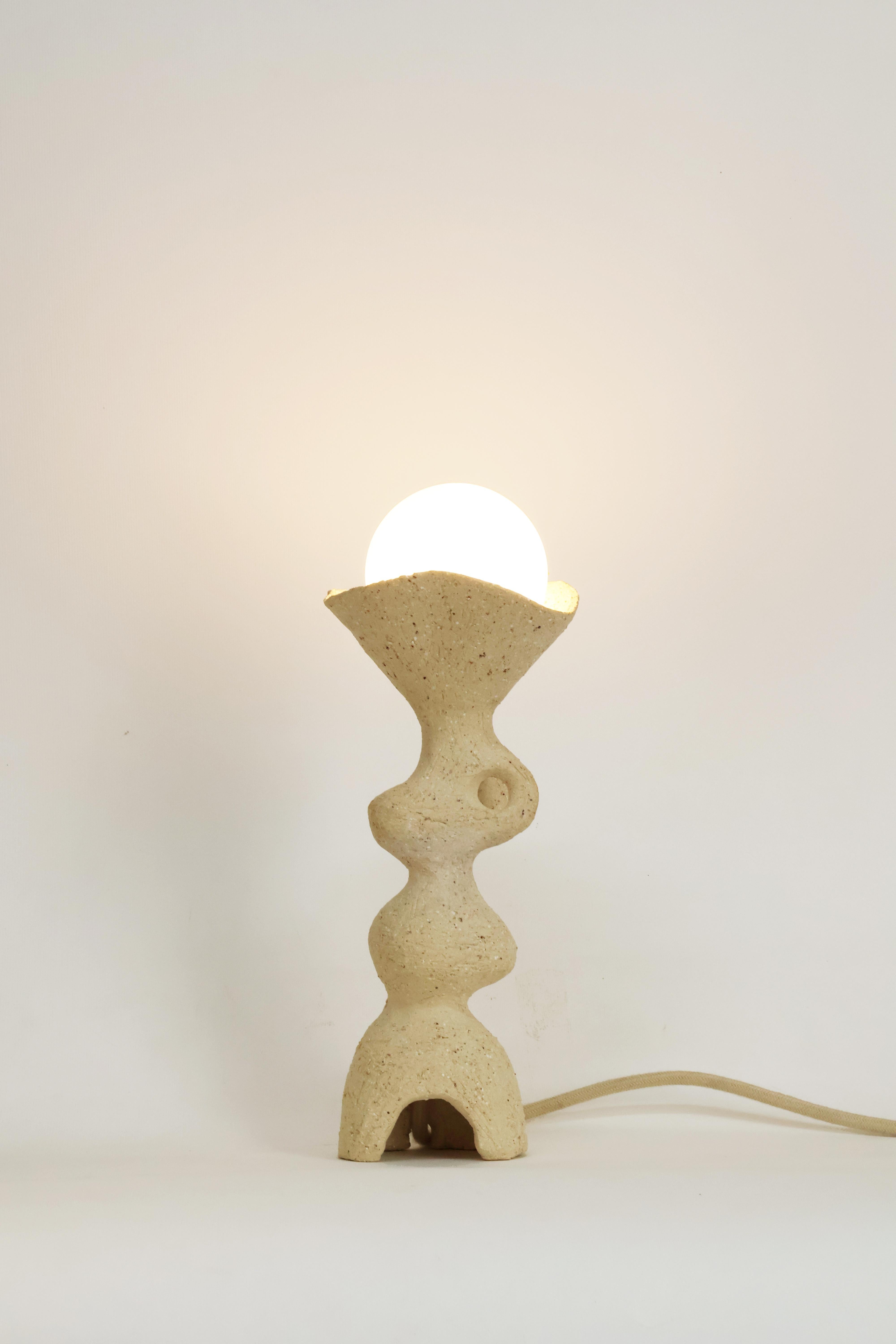 Lampe de table Totem II de Camila Apaez
Unique en son genre
MATERIAL : Grès, argile
Dimensions : 10 x H 31 cm

Ila Ceramica est née d'un processus de recherche intérieure où la céramique est devenue un espace de présence, de silence, de toucher et