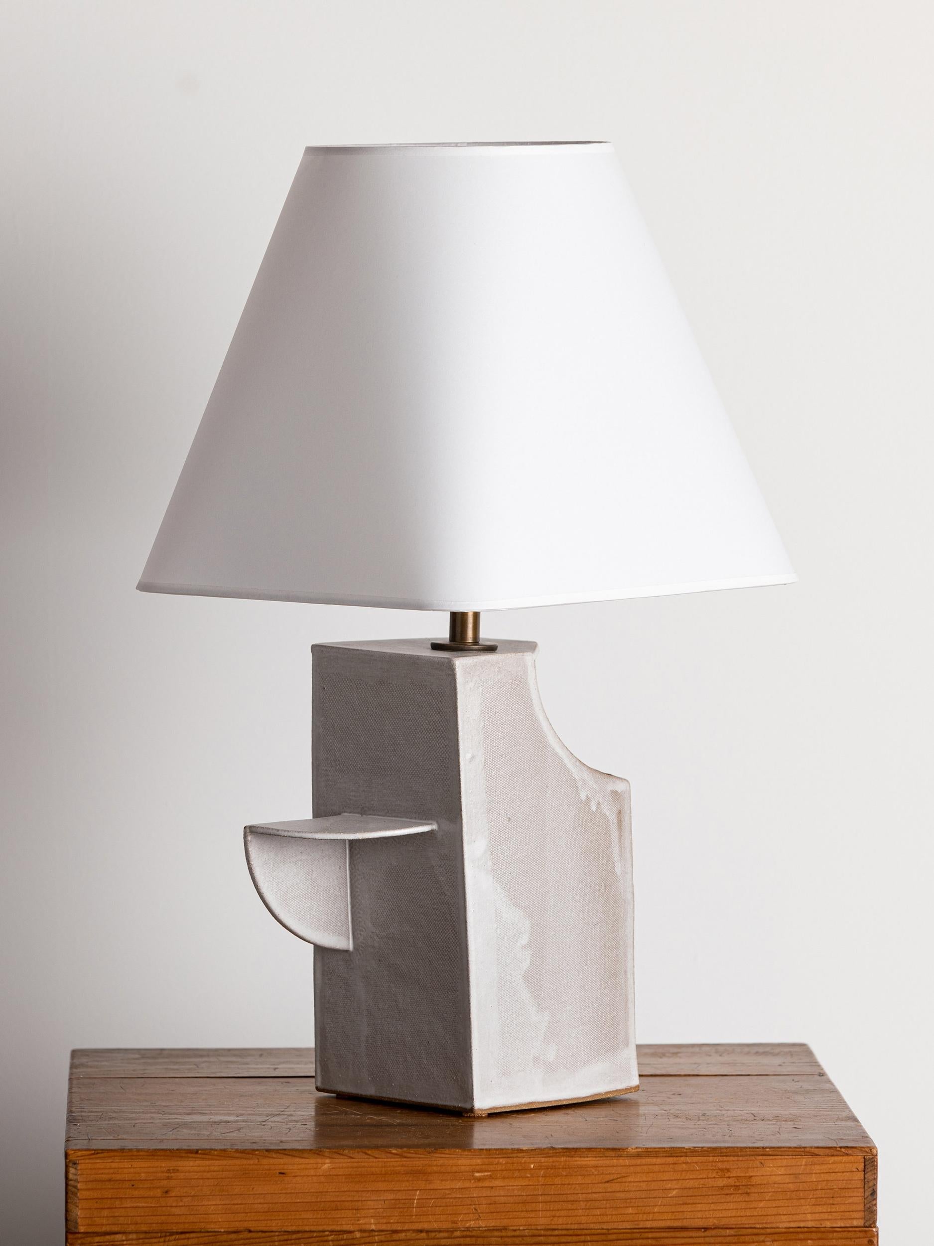 Our stoneware Totem lamp is handcrafted using slab-construction techniques.

Finish

- Dipped glaze, pictured in parchment 
- Antique brass fittings
- Twisted black-cloth cord
- Full-range dimmer socket
- Vellum shade

Bulb

60-watt