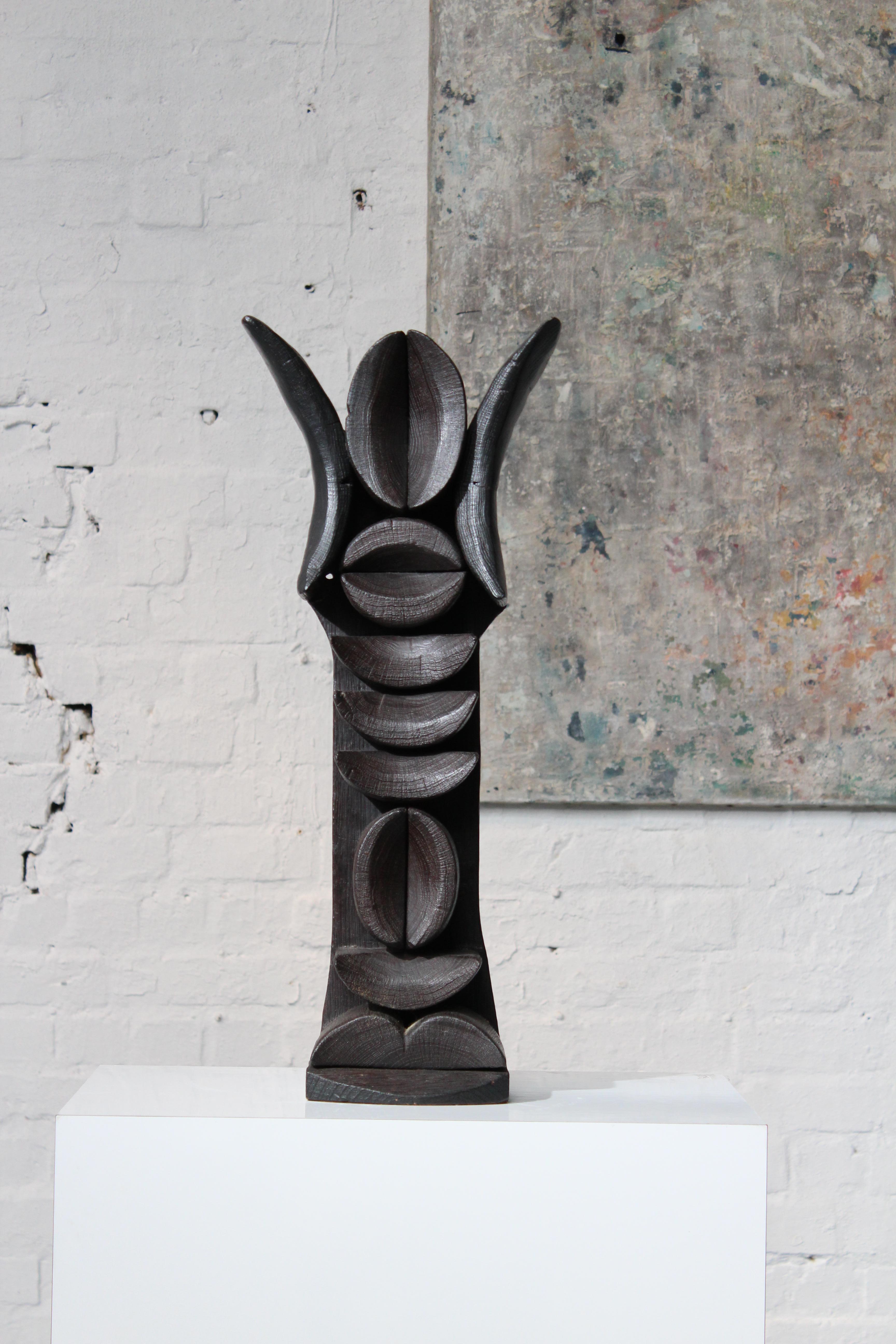 Scultura totem in quercia bruciata dell'artista belga Jacky de Maeyer, nato nel 1938 a Ostenda. La scultura ha una forma antropomorfa con influenze dell'arte africana e risale al 1971. Jacky de Maeyer è nata a Ostenda nel 1938. Ha uno studio nella