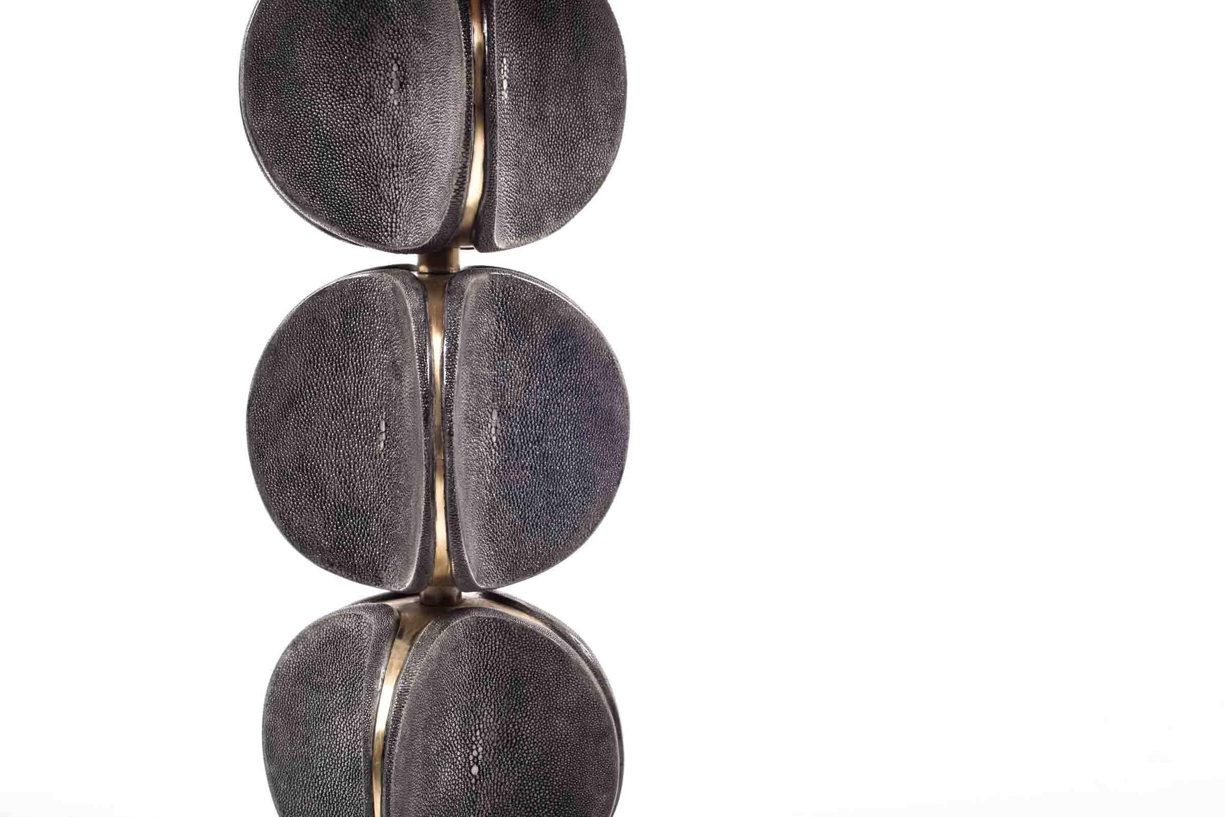 The TOTEM side table in coal black shagreen is a playful piece with it's rotating parts. These modern TOTEM-inspired parts that concave, have subtle bronze-patina brass details that frame each part. This piece makes for a chic end table. This piece