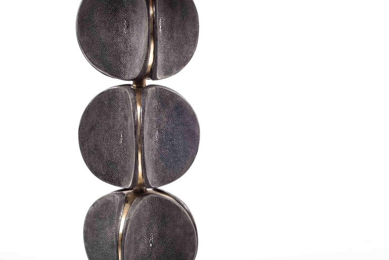 The TOTEM side table in black shagreen is a playful piece with it's rotating parts. These modern TOTEM-inspired parts that concave, have subtle bronze-patina brass details that frame each part. This piece makes for a chic end table. This piece is