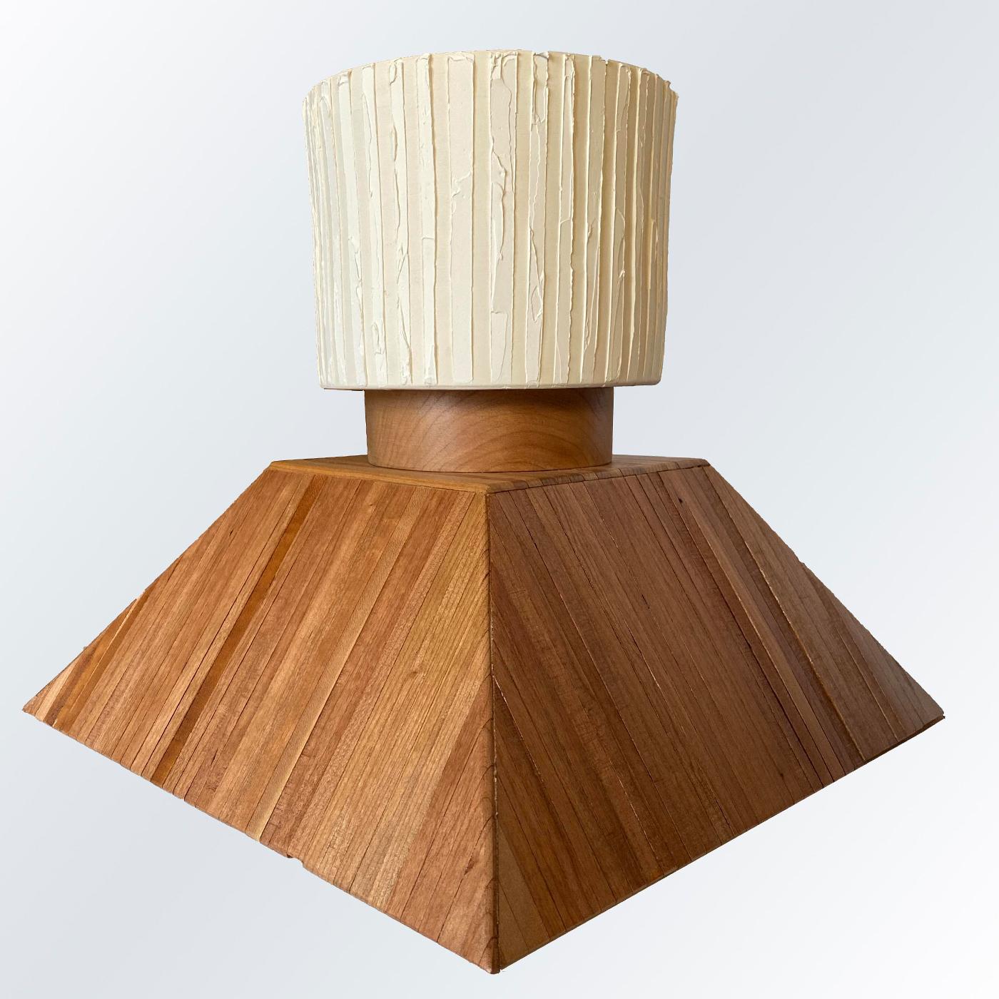 Boasting a remarkable aesthetic with a distinct, rigorous geometric influence, this table lamp is a one-off design fully handcrafted, numbered, and signed by Mascia Meccani. The ridged base in solid cherry comprises a lower element shaped like a