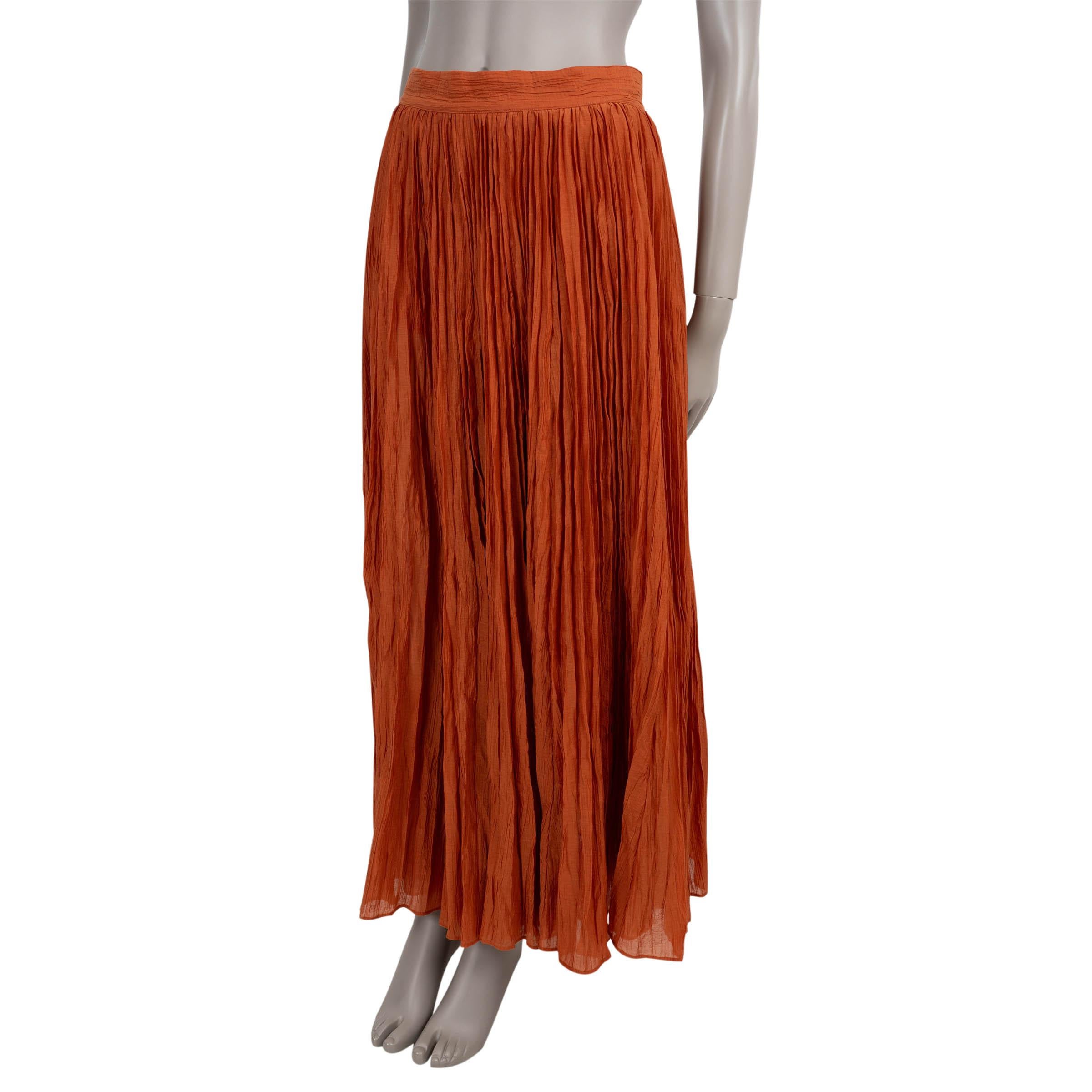 This 100% authentic Totême skirt is crafted in terracotta crinkled plissé cotton (72%) and polyamide (28%), offering lightweight texture and movement. It features a high-waisted, flared silhouette with a sweeping maxi length. A concealed zipper at