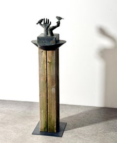 Escultura figurativa totémica, manos y pájaros de bronce patinado sobre base de columna de madera