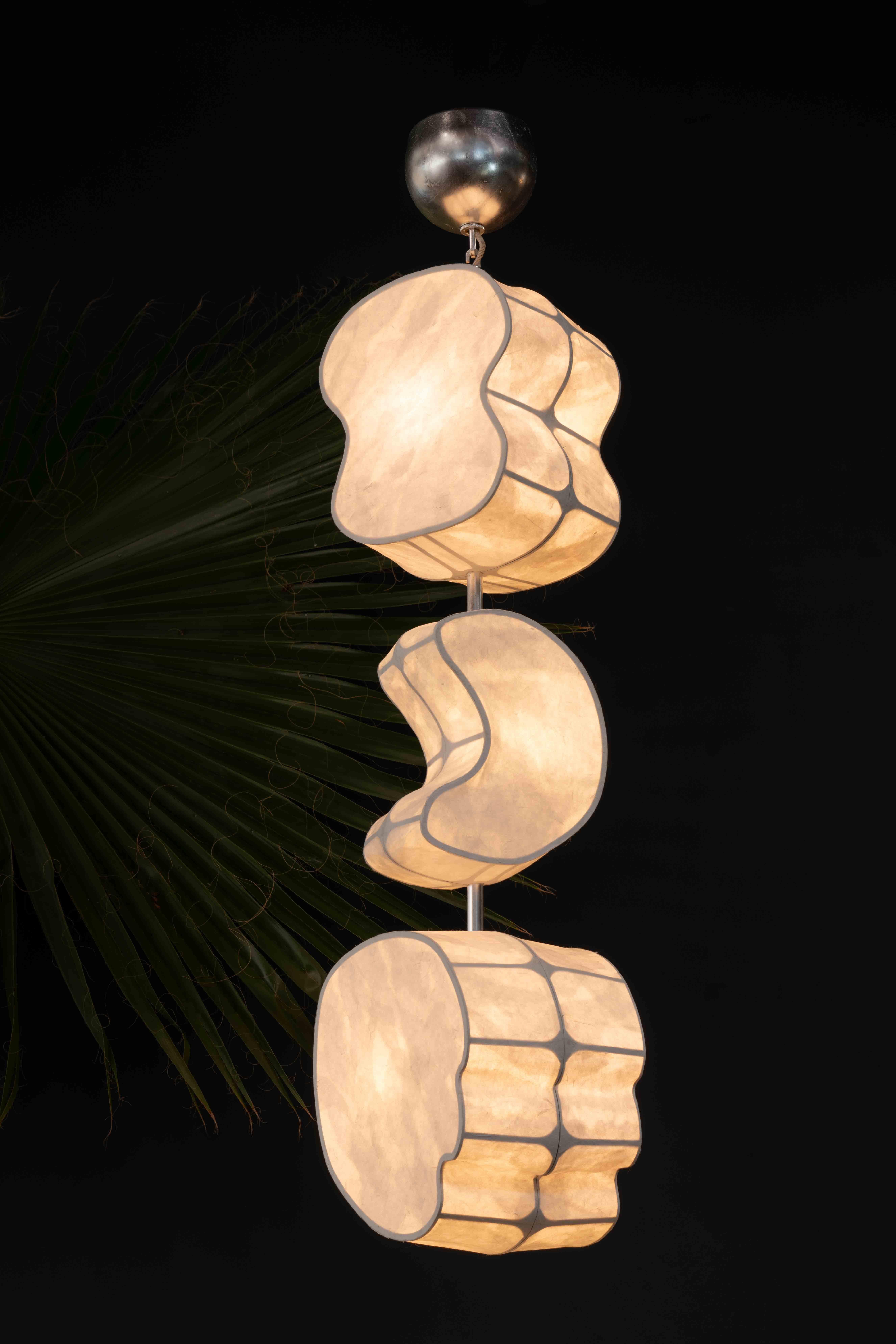 The Totemic Pendant 3(0) is a pendant chandelier with three paper shades (Sage 12, Moon 10.5, & August 12). The item in stock comes in Natural Hanji paper shades and Silver Leaf on brass.

Totemic is Andrea Claire Studio’s latest lighting