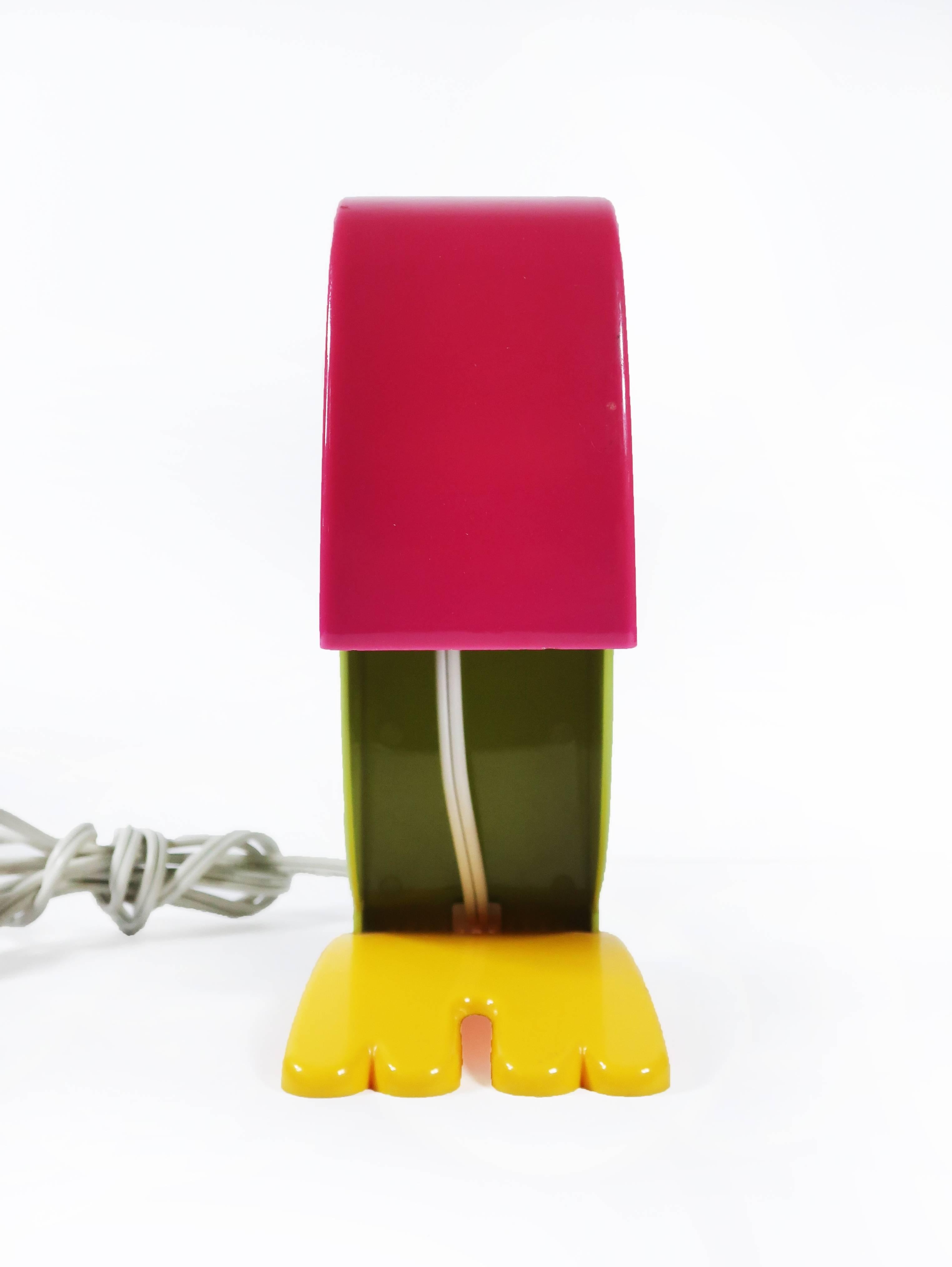 Commercialisée en 1968:: cette lampe de bureau italienne en plastique moderne:: créée par Steven Sclaroff pour Old Timer Ferrari de Vérone:: en Italie:: a un corps vert:: un bec orange:: des pieds jaunes et un œil avec une pupille noire. En ouvrant