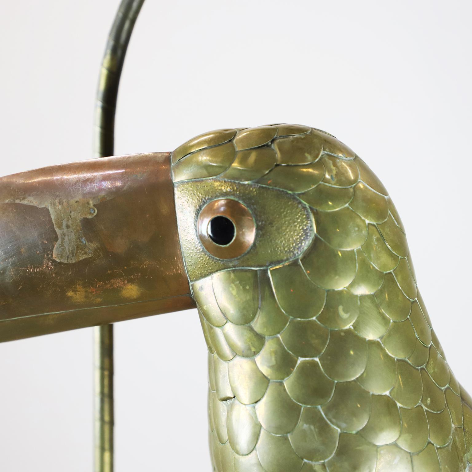 Copper, brass and aluminium Toucan on a hoop hanging stand by Sergio Bustamante, circa 1960. 

Sergio Bustamante is a Mexican Artist and sculptor. He began with paintings and papier mache figures, inaugurating the first exhibit of his works at the