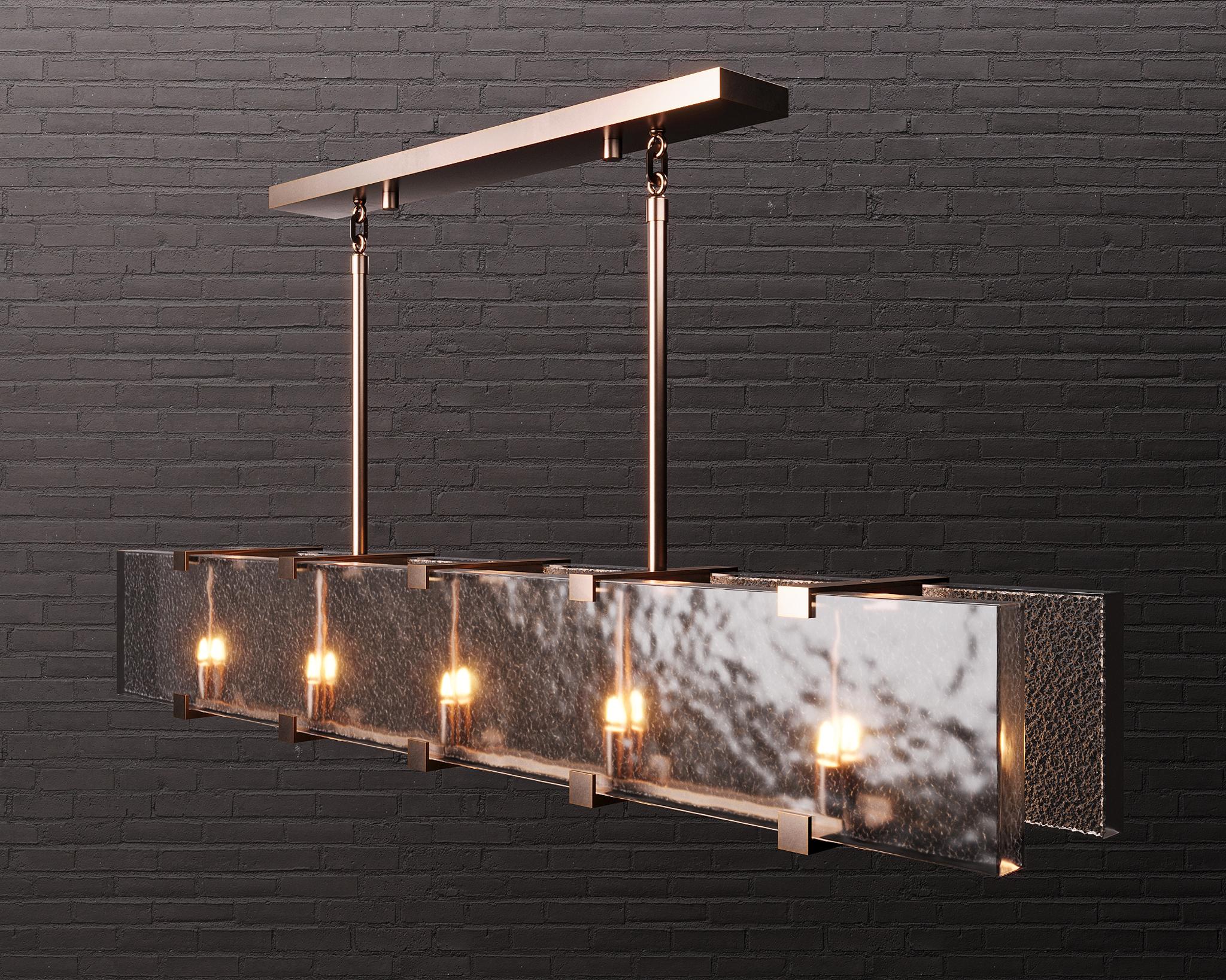 Single-cast textured glass walls glow with inner rows of light in a deceptively simple structured naturally beautiful bronze bracket frame with custom link detail.

Models in the collection are individually hand-crafted by the skilled artisans in