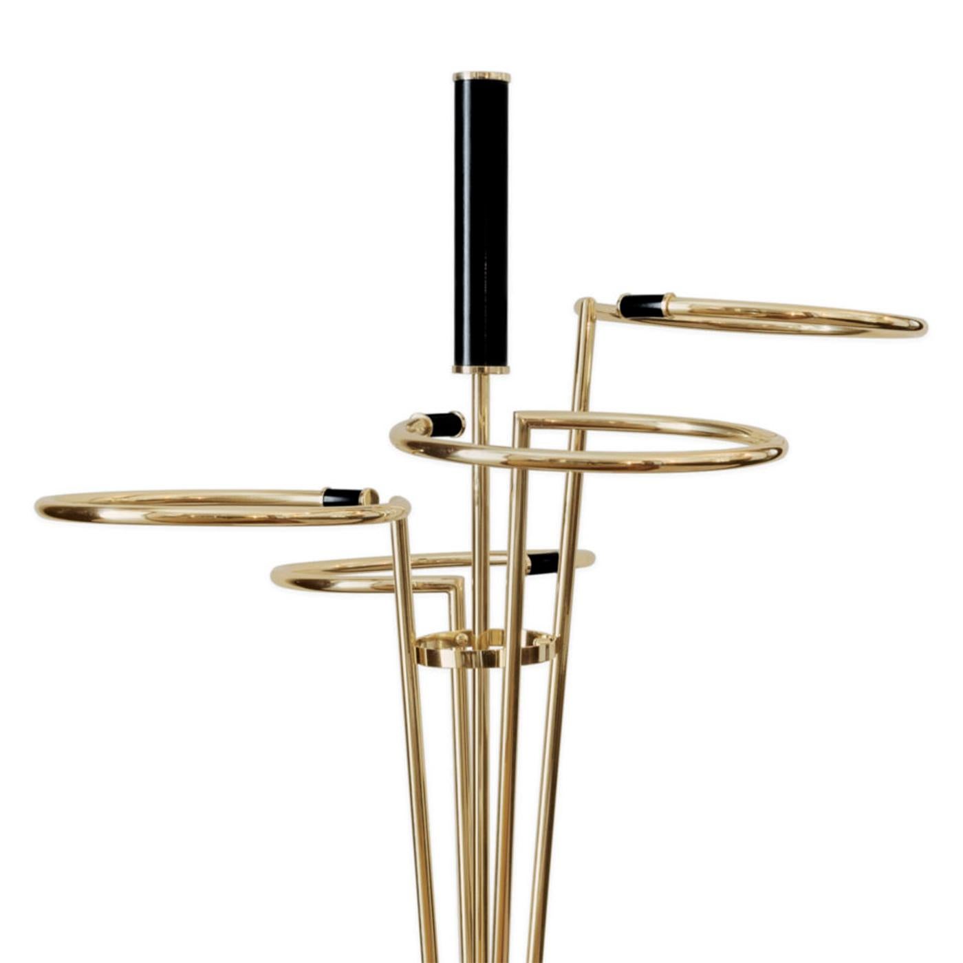 Umbrella stand Touquet with polished Carrara marble
base. With structure in stainless steel in gold finish and
with a black handle. With 4 rings made to contain 4 to 8
umbrellas.
 