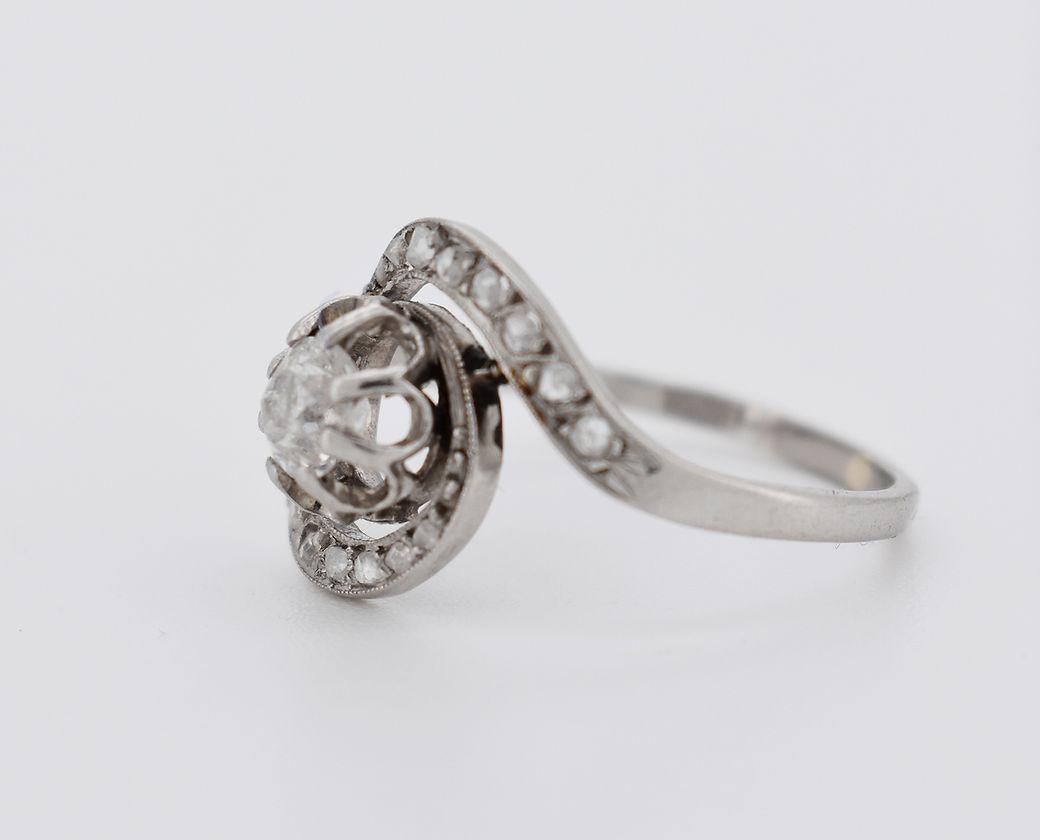 Twirl Ring, circa 1900 in Platinum. It is adorned with an old-cut diamond of approximately 0.30 carats, and a swirl of rose-cut diamonds totaling approximately 0.20 carats.

Detailed Characteristics:

Period: Belle Époque (circa 1900)
Weight: