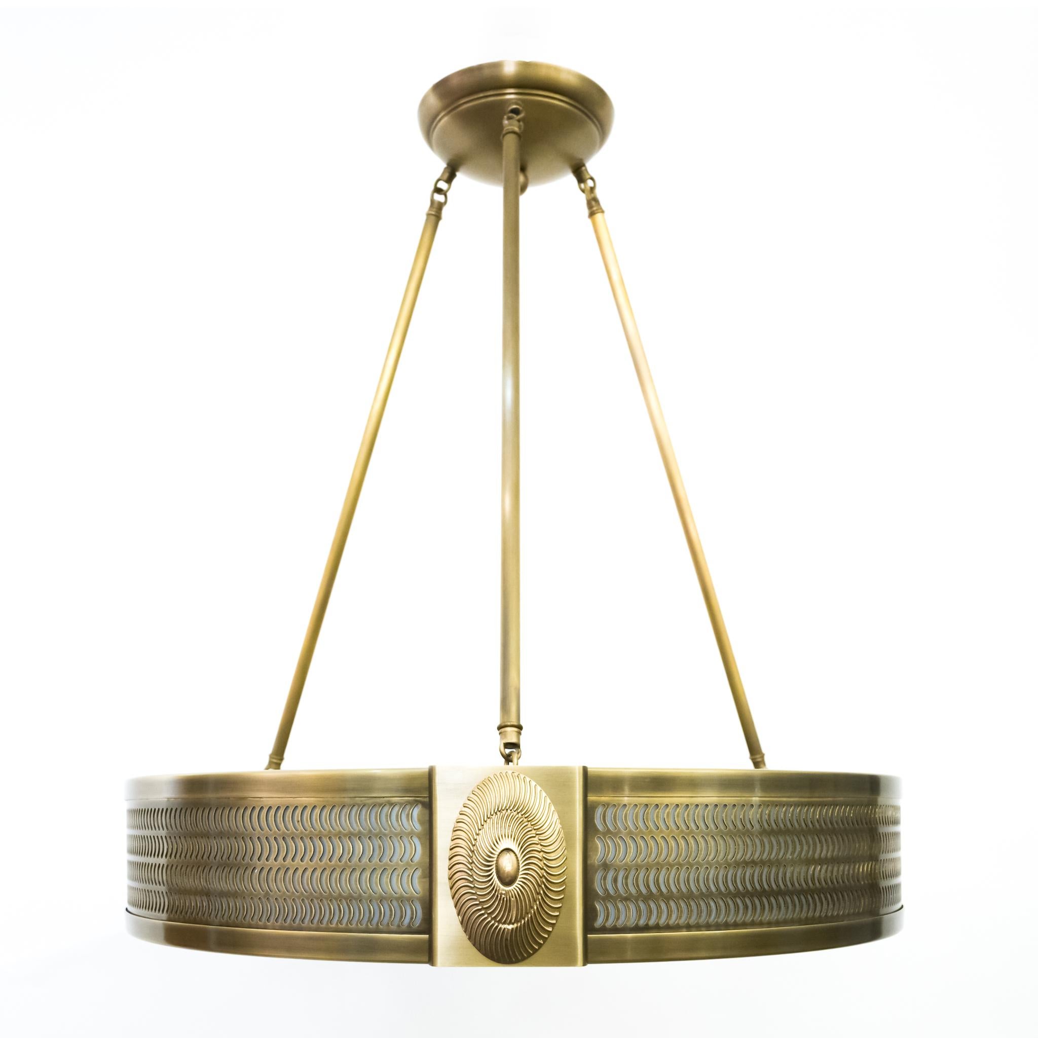 A new, contemporary pendant ceiling light with comma-shaped cutouts emitting light through opal lucite diffusers on the sides. The frame divided in three sections with cast brass oval rosettes. The underside with optical Tourbillon Swirl design in