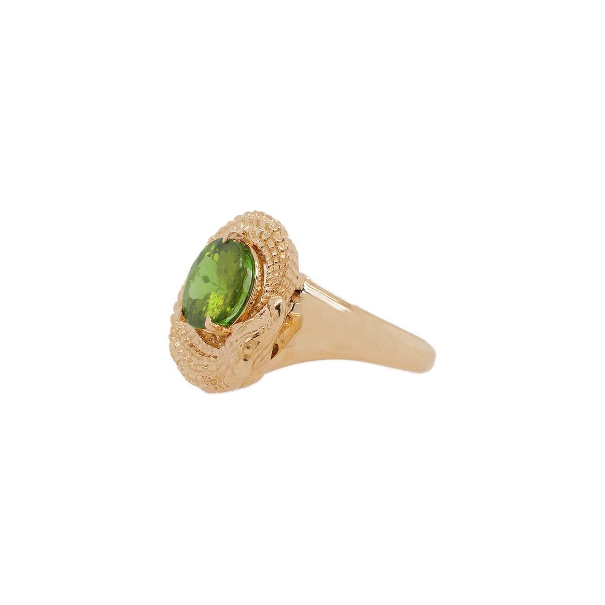 This unique ring design features a center round tourmaline stone with a textured alligator eating its own tail, reminiscent of an ouroboros snake, representing the belief in reincarnation and the cosmic cycle we all live & breathe in. A piece that's