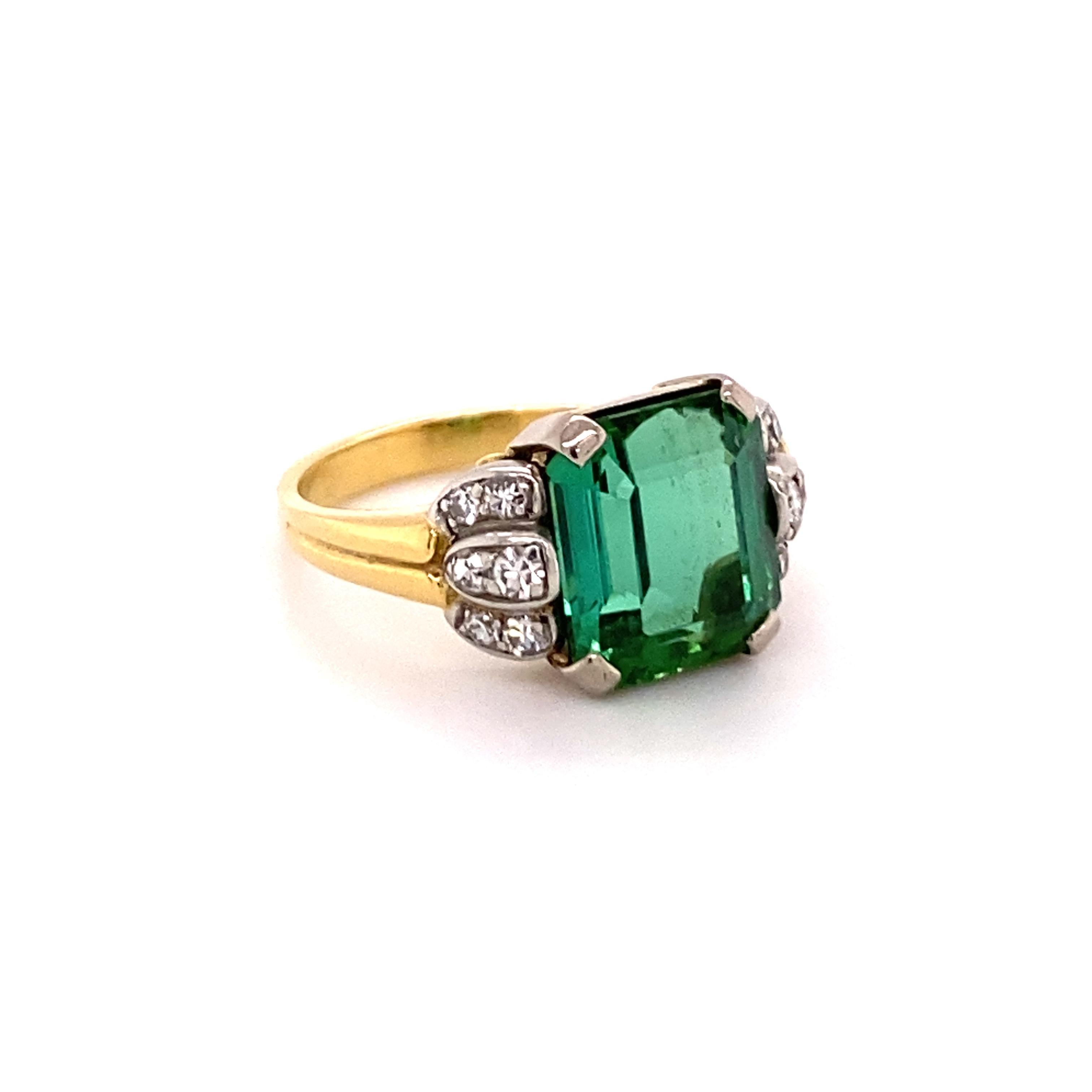 This sparkling ring features a vibrantly coloured green tourmaline of approximately 4.90 carats. This octagonal centre stone is accented by 12 single cut diamonds of H/I colour and si/i clarity, total weight approximately 0.24 carats. 
The setting