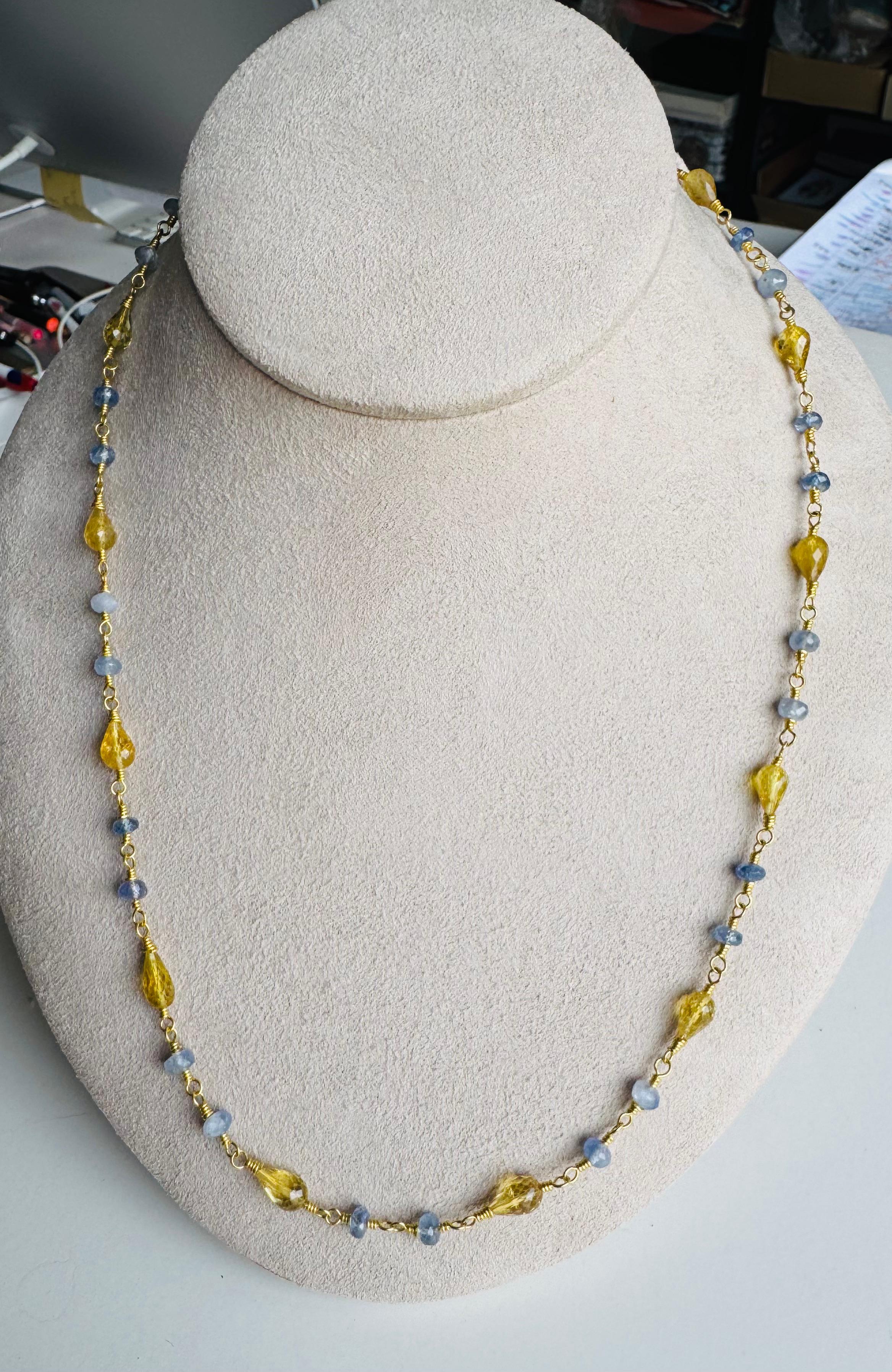 Rare perle di tormalina gialla a forma di pera, splendidamente sfaccettate, sono intervallate da vibranti zaffiri blu di Ceylon per creare un delicato e luminoso gioco di colori. Gli zaffiri ammontano a 19,20 carati, con 18,5 carati di tormalina