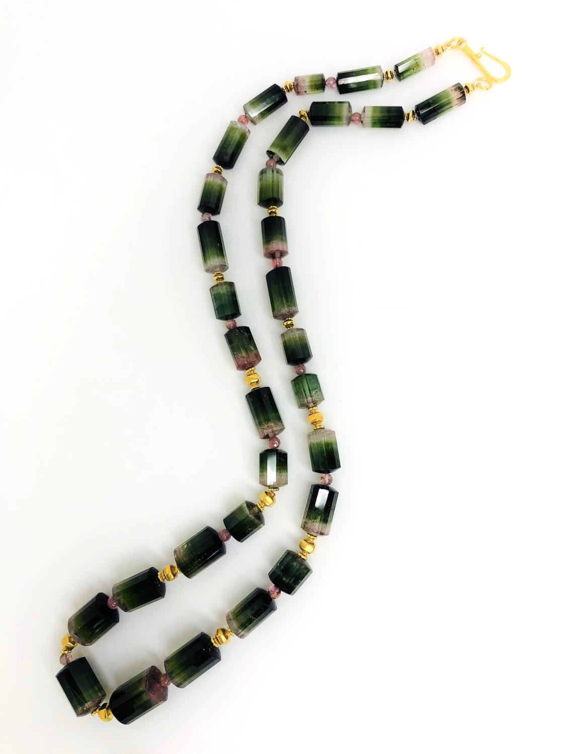 This unusual necklace features 395 carats of tourmaline crystal beads that have been hand strung with 22k yellow gold accents! The modified cylindrical shape beads are a collection of bi-colored and tri-colored tourmaline in a range of greens, pinks
