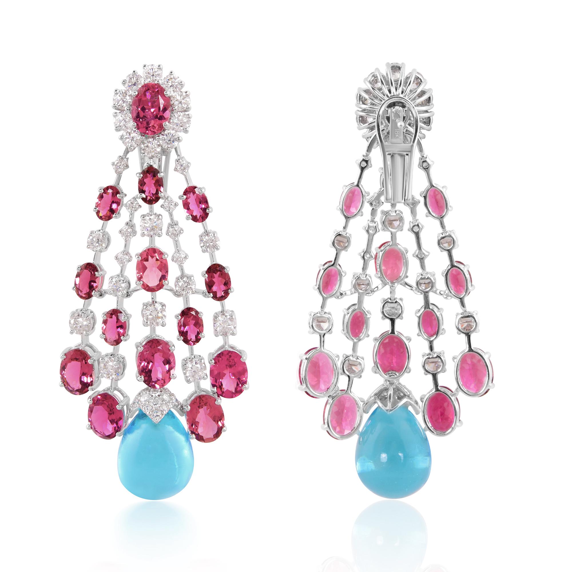 The focal point of these earrings is the enchanting Tourmaline Blue Topaz gemstones, radiating a captivating hue reminiscent of tranquil ocean depths. Their elongated dangle design ensures graceful movement with every turn, catching the light and