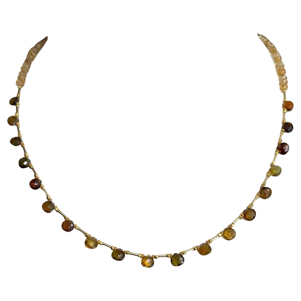 Questa graziosa collana di tormalina e citrino presenta una collezione di perline briolette di tormalina a forma di pera e rondelle di citrino sfaccettate, infilate a mano su un filo di seta con accenti in oro giallo. Le tormaline verdi e ambrate si