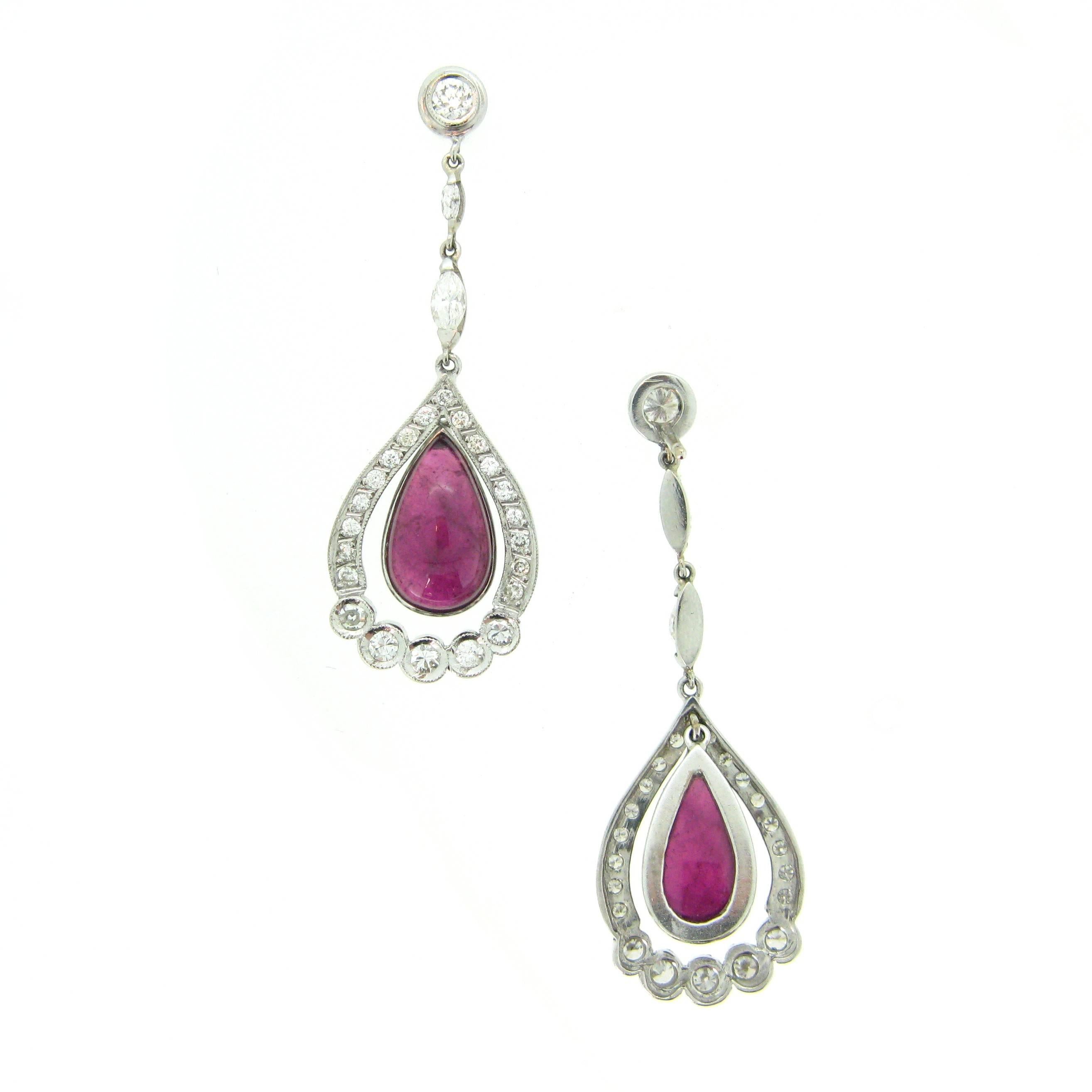 This pair of pendant earrings is very elegant. They are made in 18kt white gold. They feature two cabochon pear shaped tourmaline surrounded by diamonds. There are 46 round cut diamonds weighing an approximate total carat weight of 1ct and there are