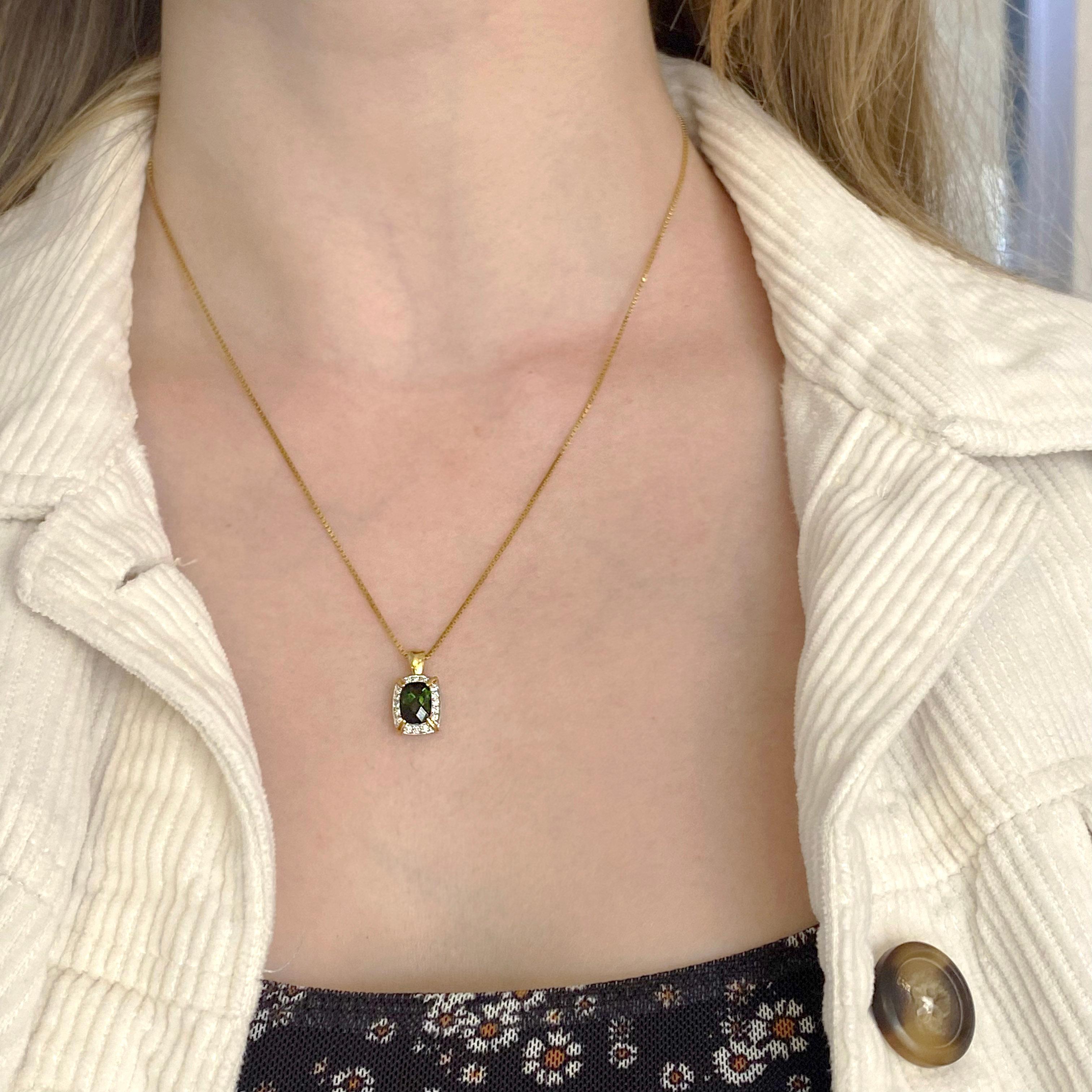 This stunning chrome tourmaline is set in a very unique setting that has both 18 karat yellow gold and white gold. It hangs from a beautiful 18 karat yellow gold box chain. The tourmaline is an elongated cushion shape that has checkerboard faceting