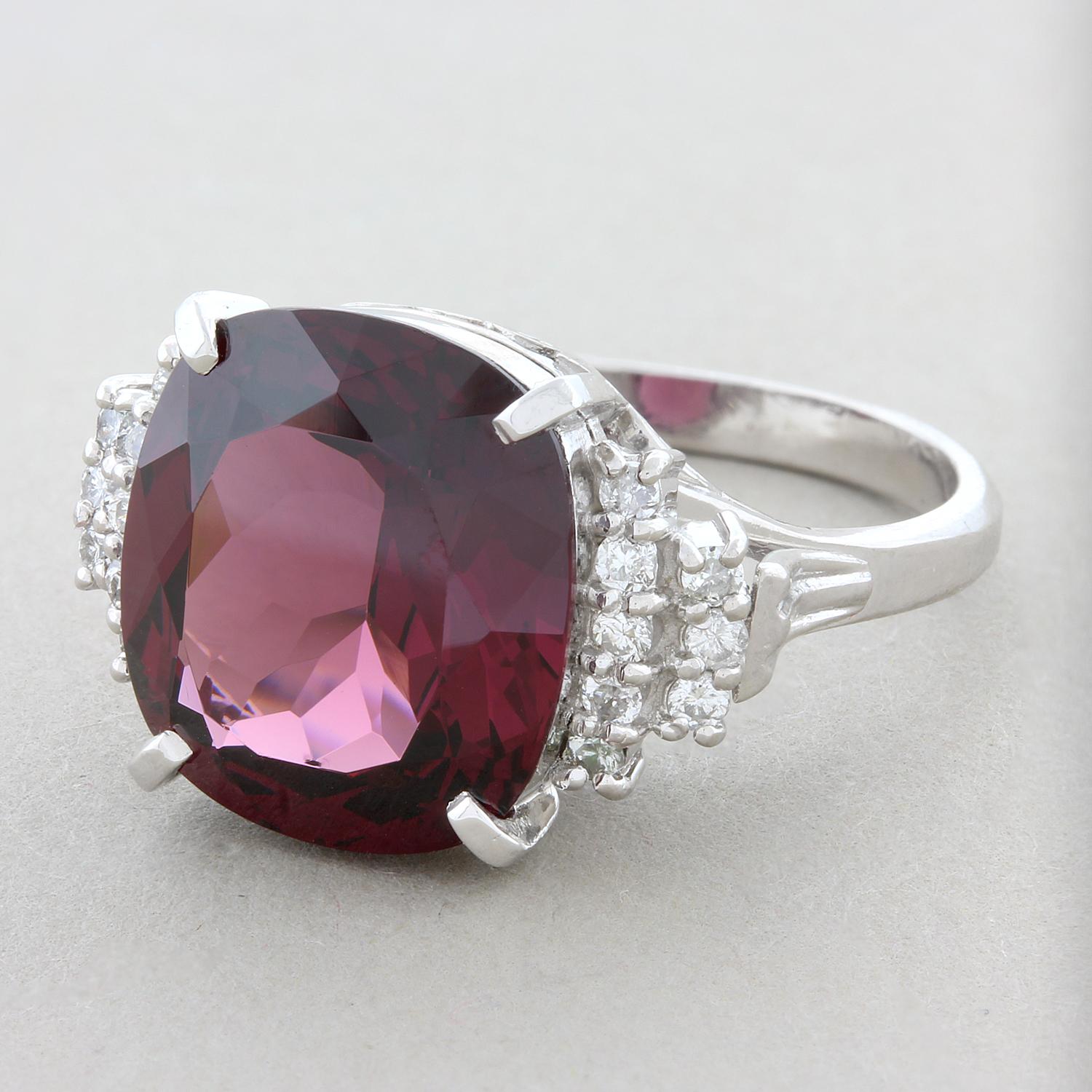 A vivacious 8.15 carat deep purplish red garnet in a platinum setting. The cushion cut garnet is accented with a staircase of round cut diamonds on each shoulder weighing 0.23 carats. The craftsmanship of this ring parallels the brilliance of this