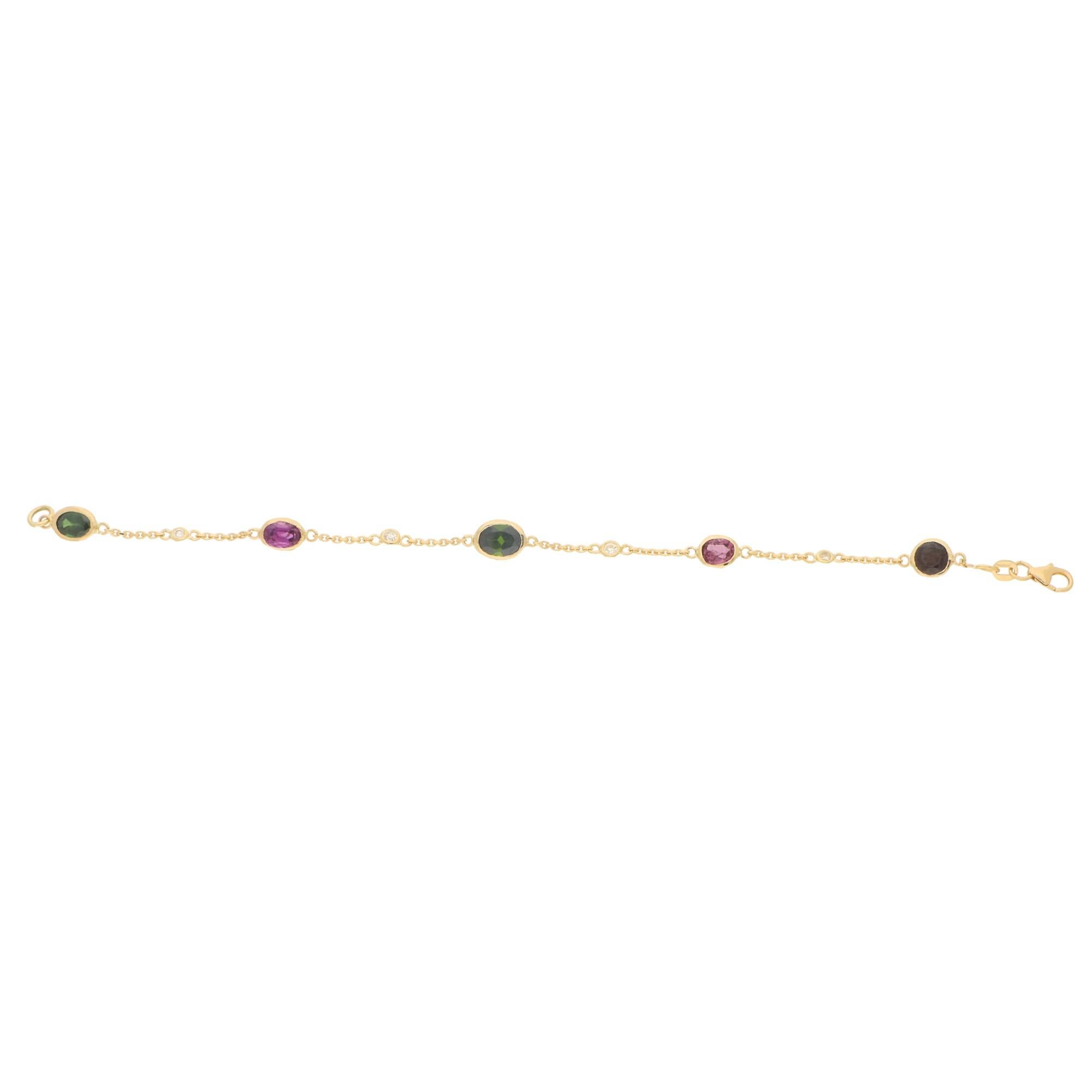An elegant green and pink tourmaline and garnet spectacle bracelet set in 18k yellow gold. The piece is composed of a mixture of five vibrant pink and green tourmalines and a single garnet each being separated by a rub over set round brilliant cut