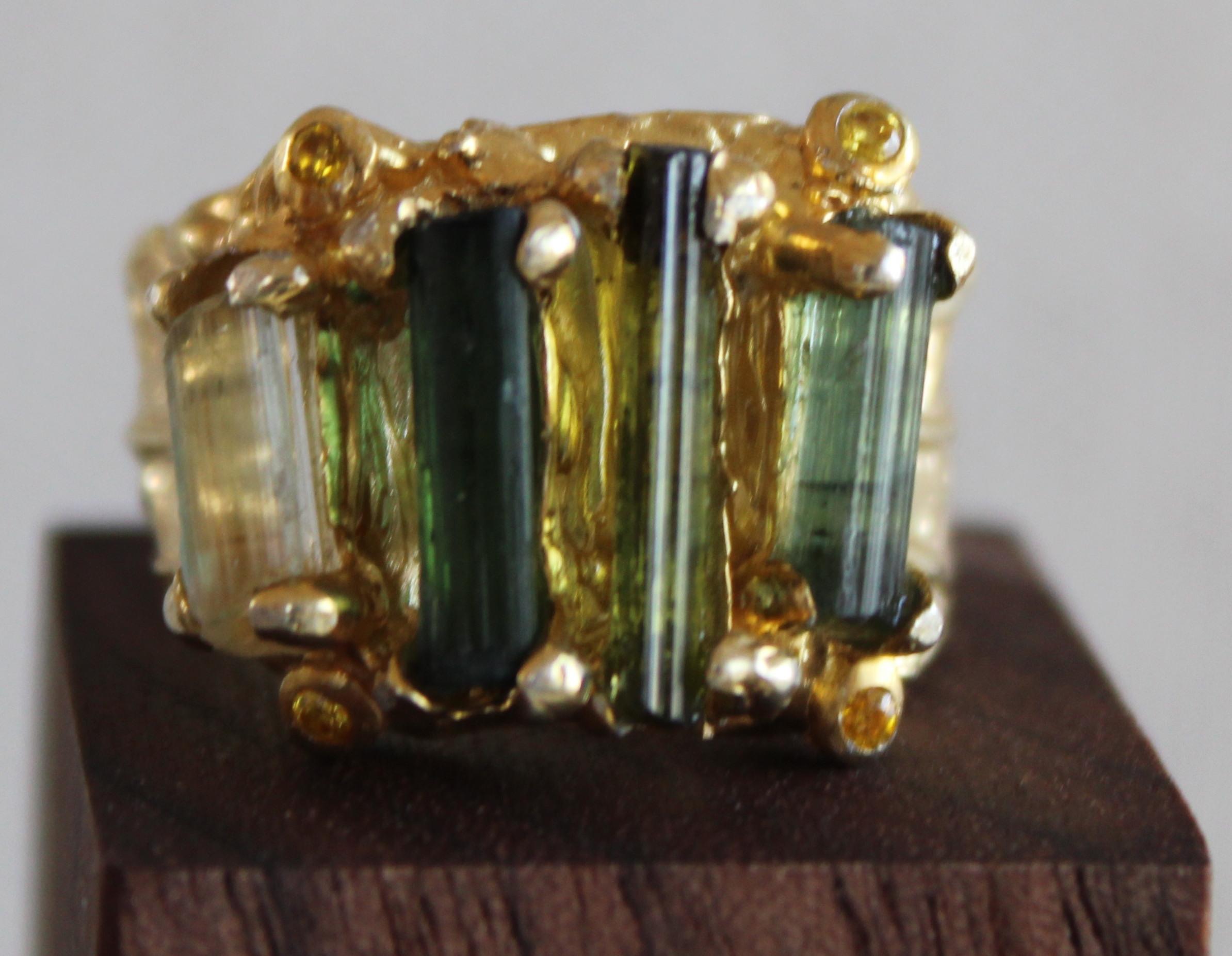 Beautiful Tourmaline cocktail ring. This ring is size 7.5 meant to be worn as a cocktail or fashion ring The ring is cast in sterling silver and plated in 14K gold vermeil. Four raw tourmaline stones are set in the ring vertically ranging from light