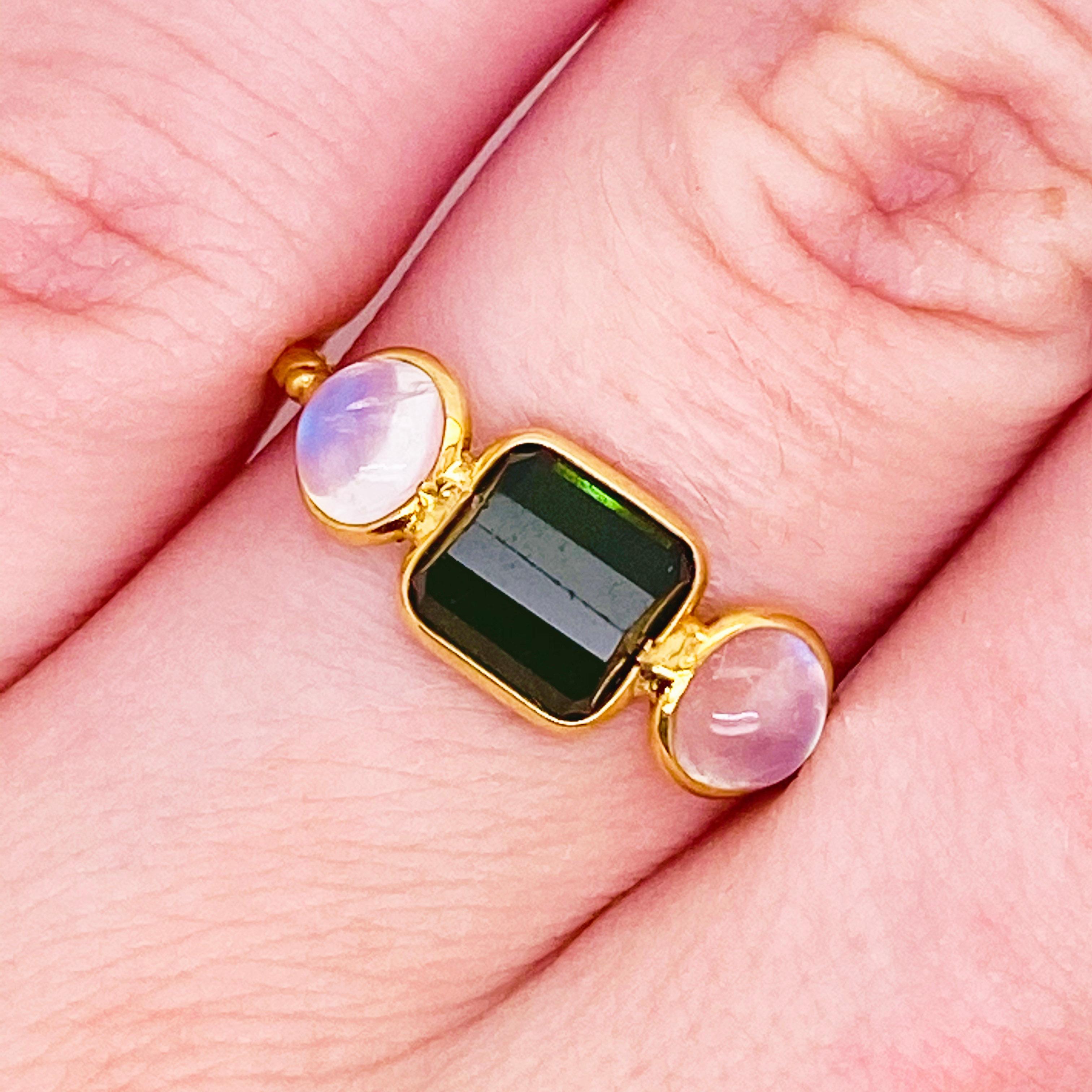 These stunningly beautiful moonstones and tourmaline set in 18kt yellow gold would make anyone thrilled to receive them! This ring provides a look that is very modern and classic at the same time! This ring is very fashionable and can add a touch of